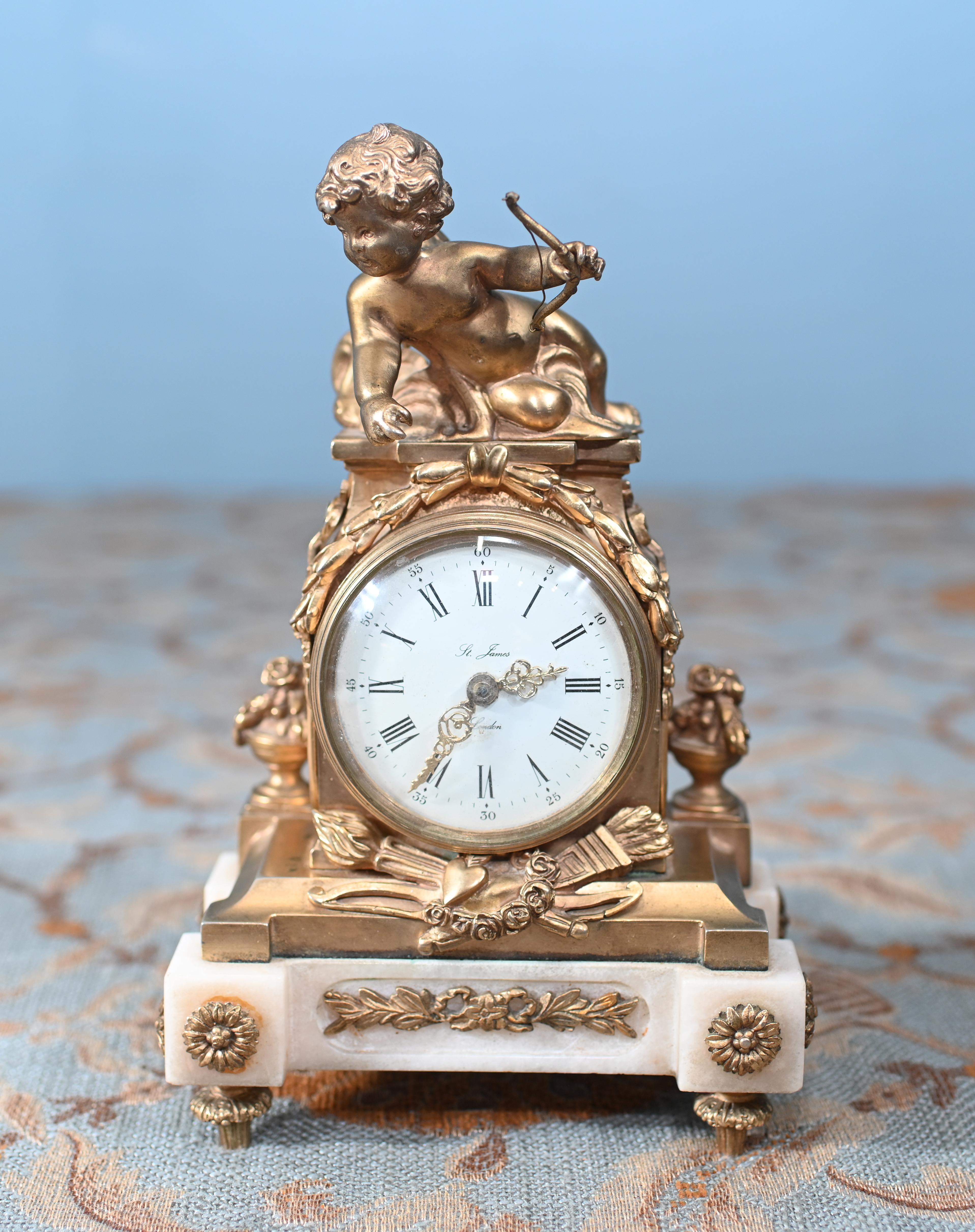 Estás viendo un precioso reloj de chimenea inglés antiguo, dorado y de mármol
Coronado por un querubín dorado regordete con alas
Fundición muy ornamentada en el dorado
La esfera del reloj lleva la firma 