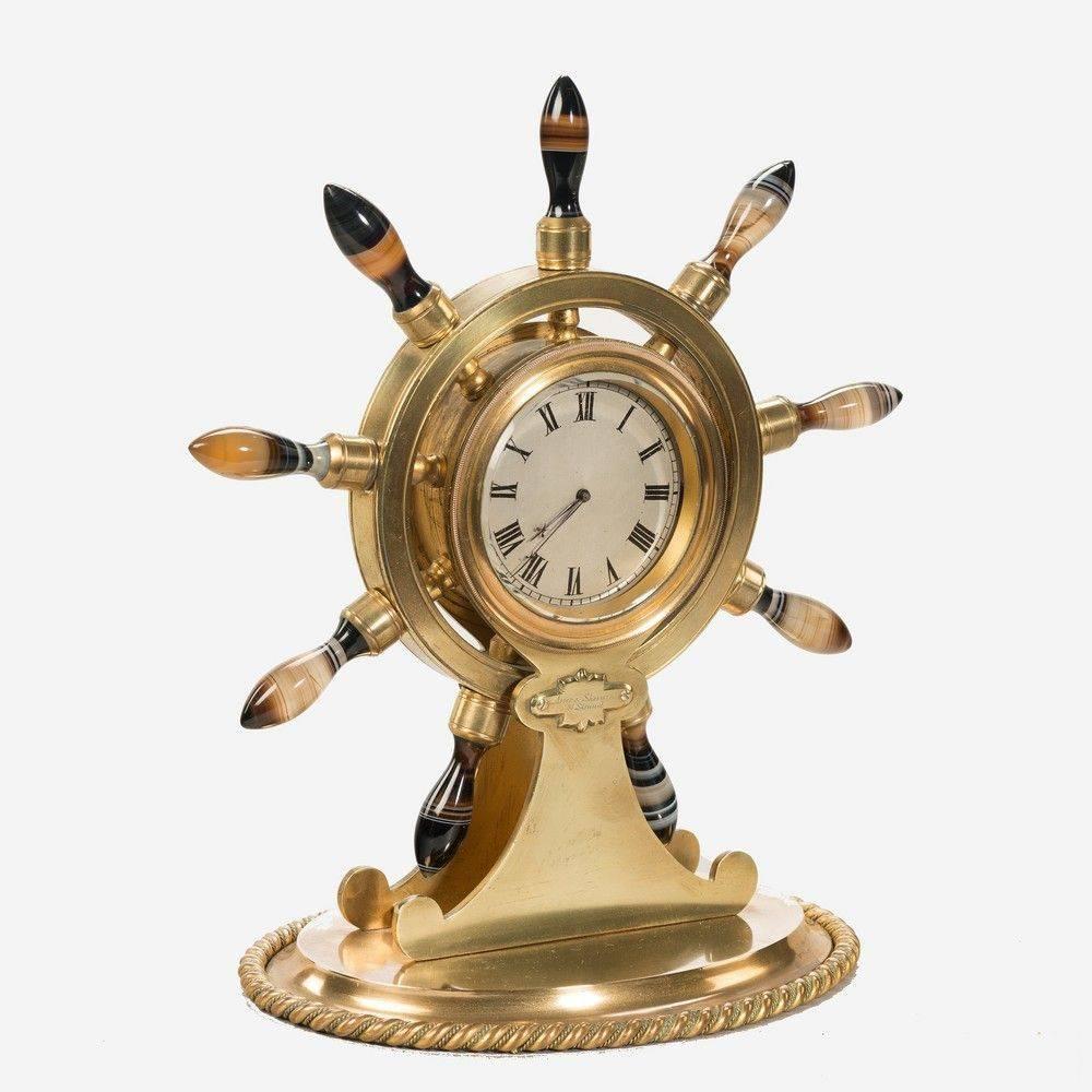 English gilt metal desk clock in the form of a ship's wheel with stone handles, retailed by Asser and Sherwin, The Strand, London.