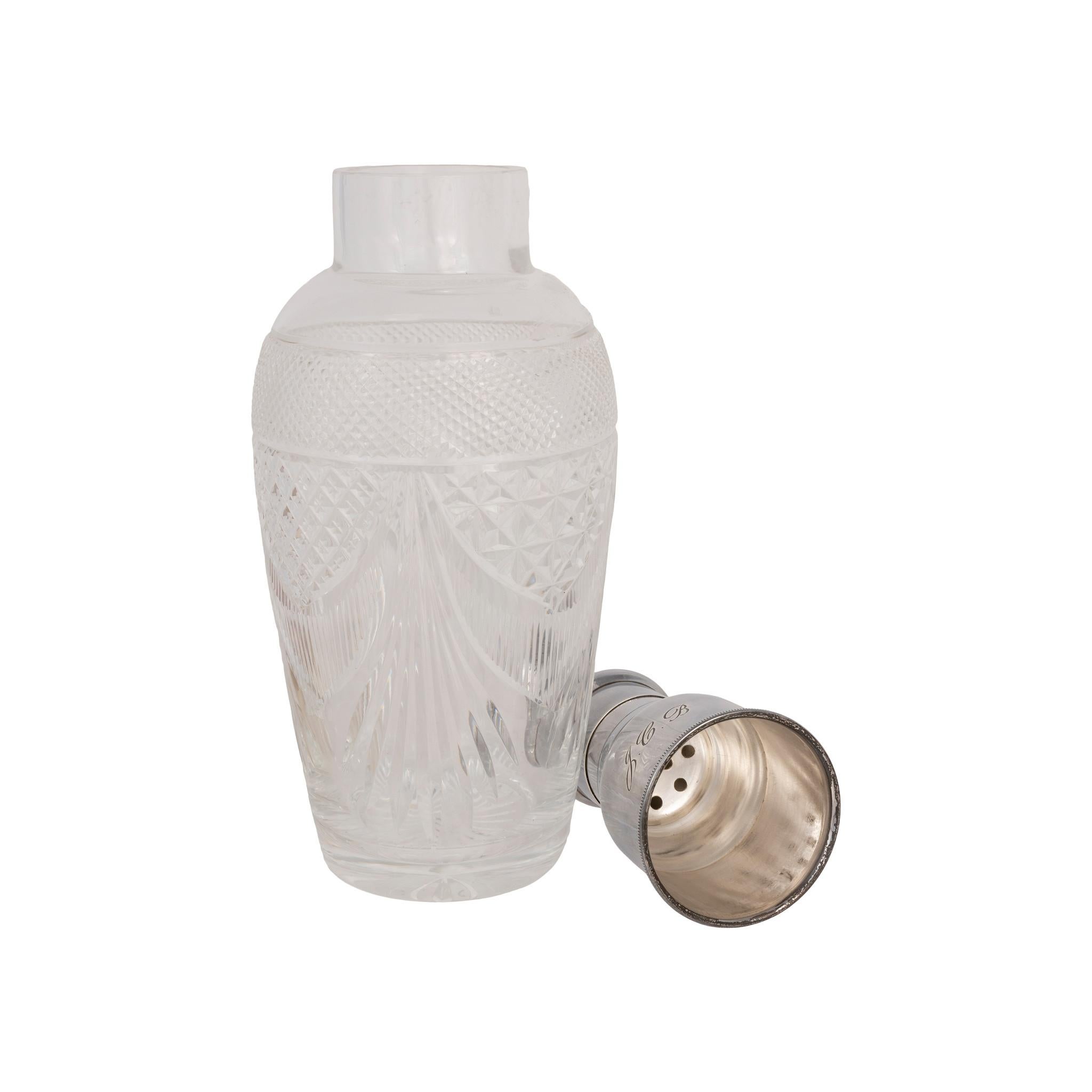 Shaker anglais en argent sterling et verre. Poinçonné Birmingham 1951 - 1952 par John Grinsell & Sons. Corps en verre vasiforme décoré d'une bande de diamants taillés et d'éventails de diamants croisés. Collier et capuchon de crépine balustre en