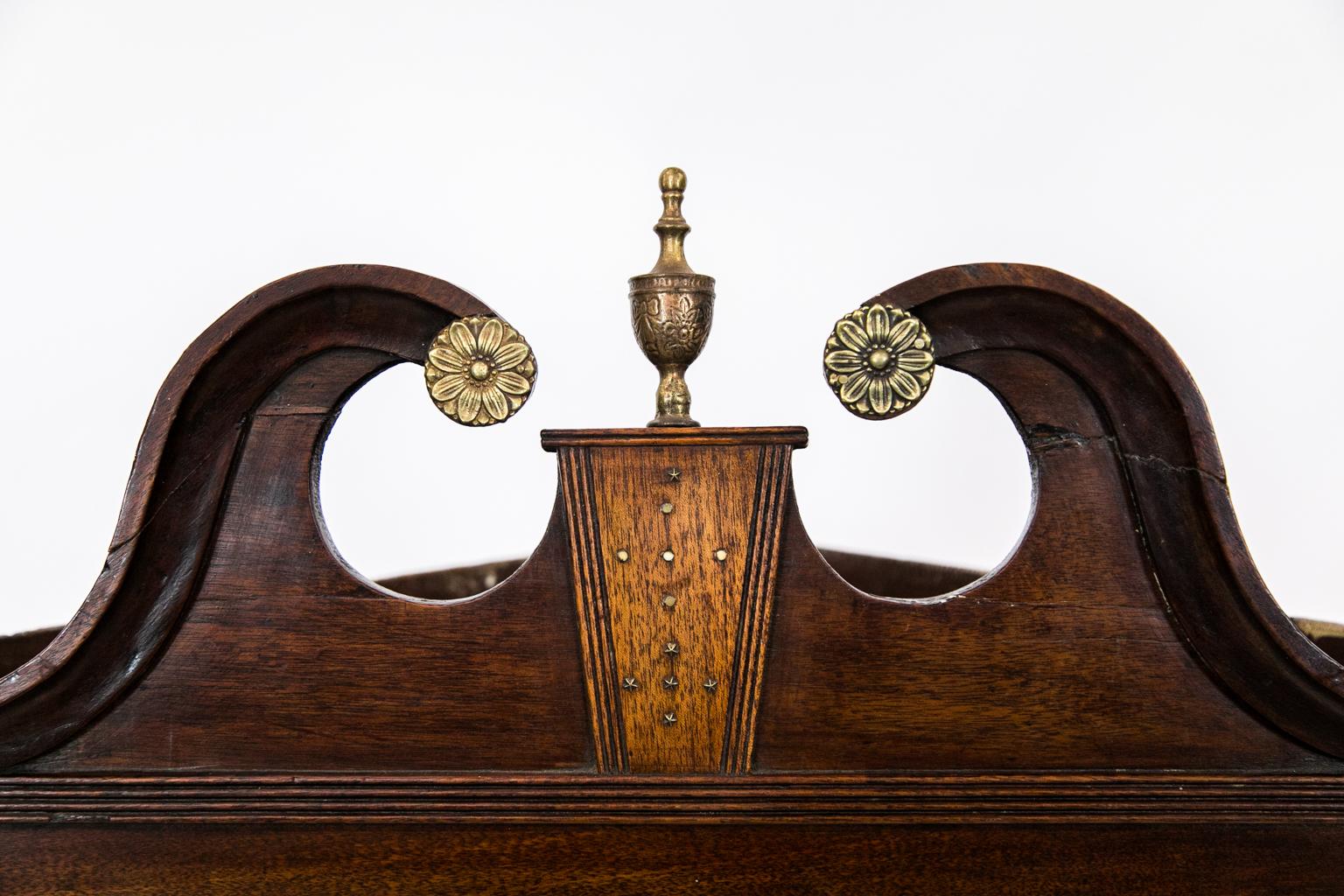 English glass door hanging corner cupboard, the mahogany George III period cupboard having its original broken arched pediment with brass rosettes and finial, satinwood veneered keystone, 13 pane astragal pattern in the door, shaped interior shelves.