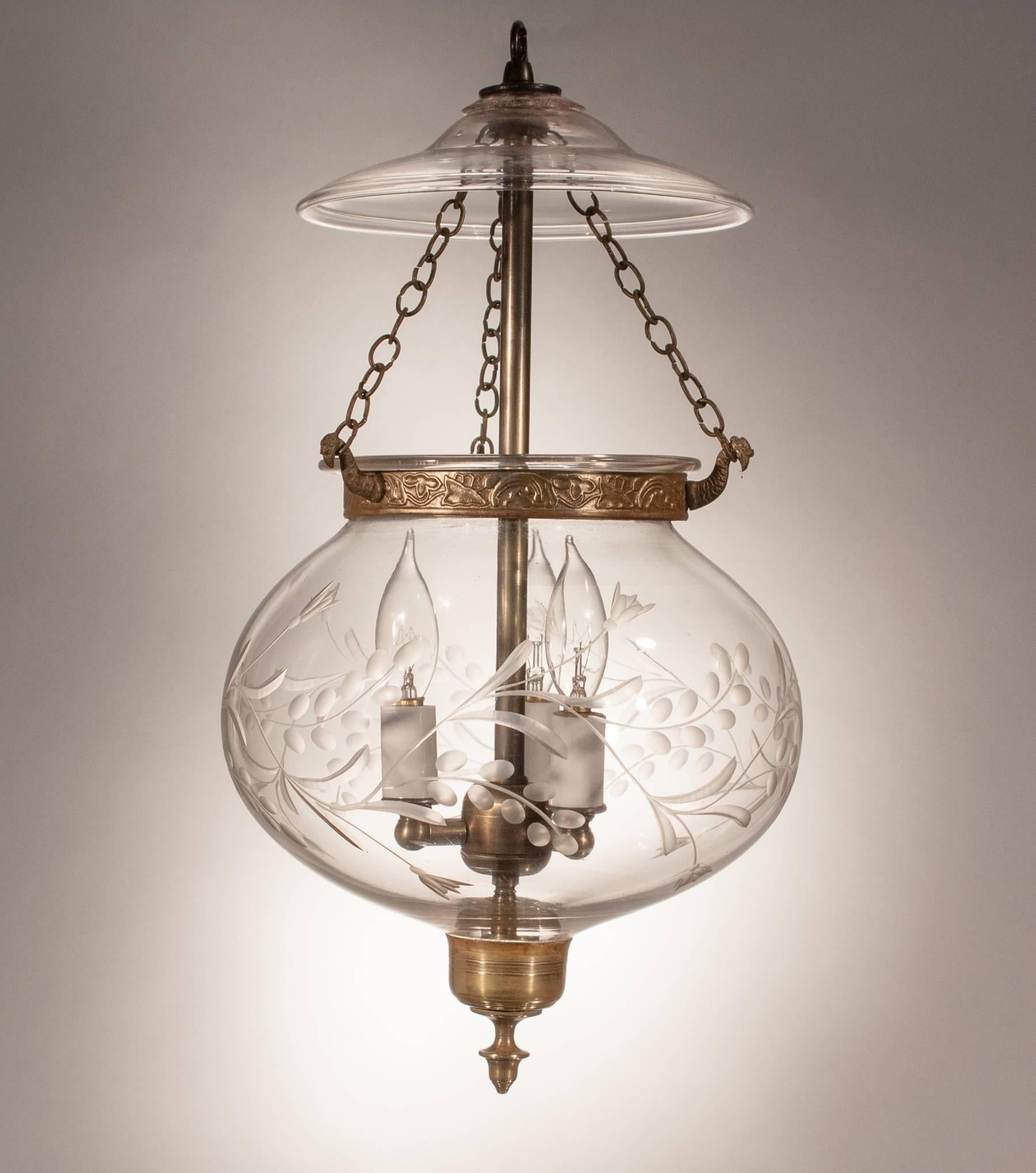 A charming 19th century handblown glass globe bell jar lantern with beautiful contours that are complemented by an etched vine motif. The hall lantern has its original brass candle holder finial base and its glass smoke bell. Its embossed brass