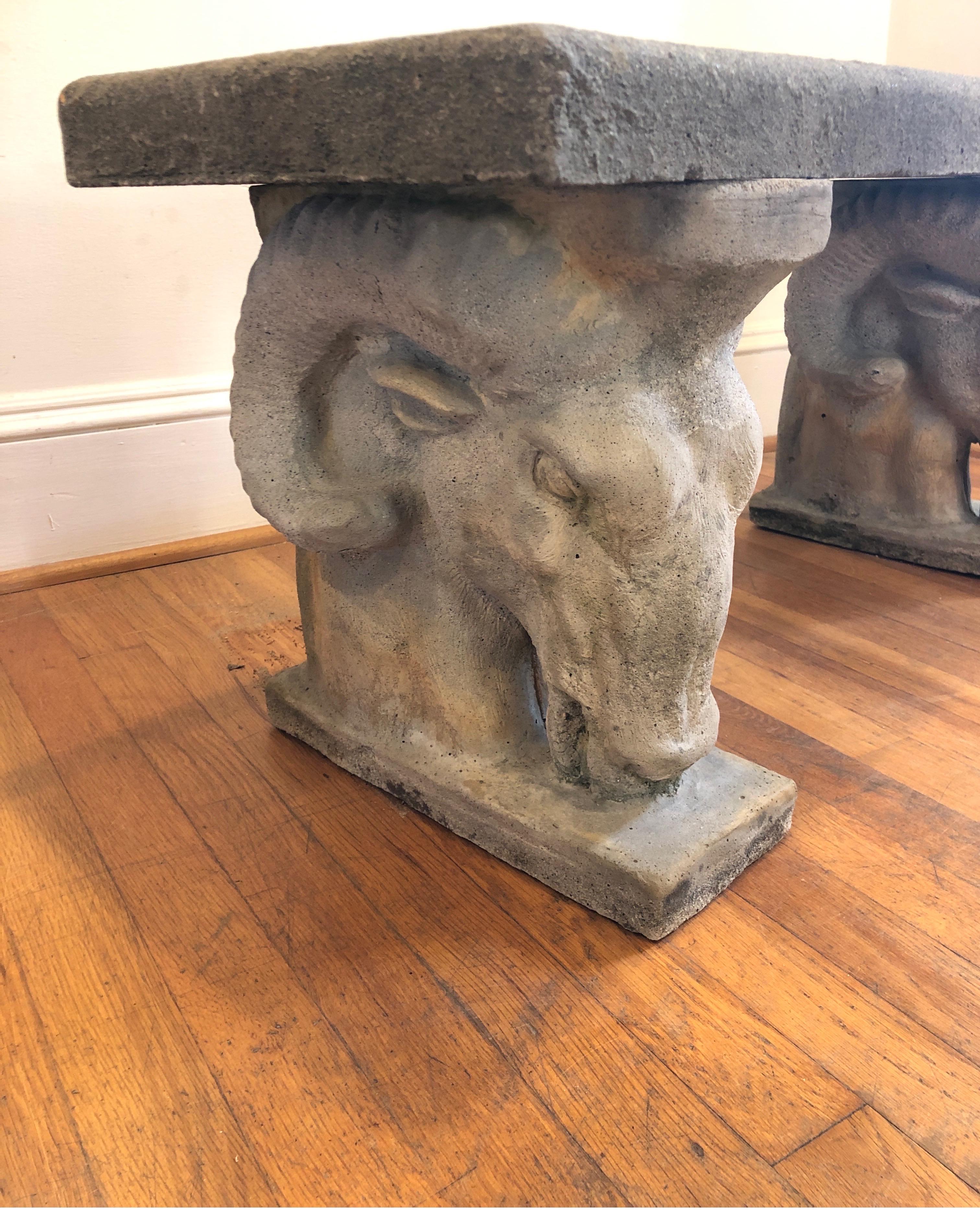 A large English Goat/Ram Head garden bench of composition stone. Rectangular stone set upon two ram heads. 

Perfect for a garden room or conservatory.