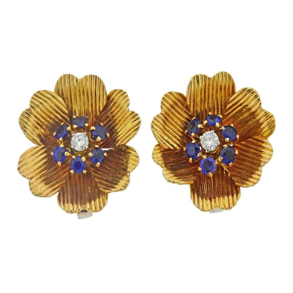 18k yellow gold flower set, includes one large and one small brooch, plus a pair of flower earrings. Brooches measure 31mm x 22mm and 58mm x 40mm. Earrings measure 20mm x 20mm. All set with blue sapphires and approx. 0.55ctw in diamonds (total). All
