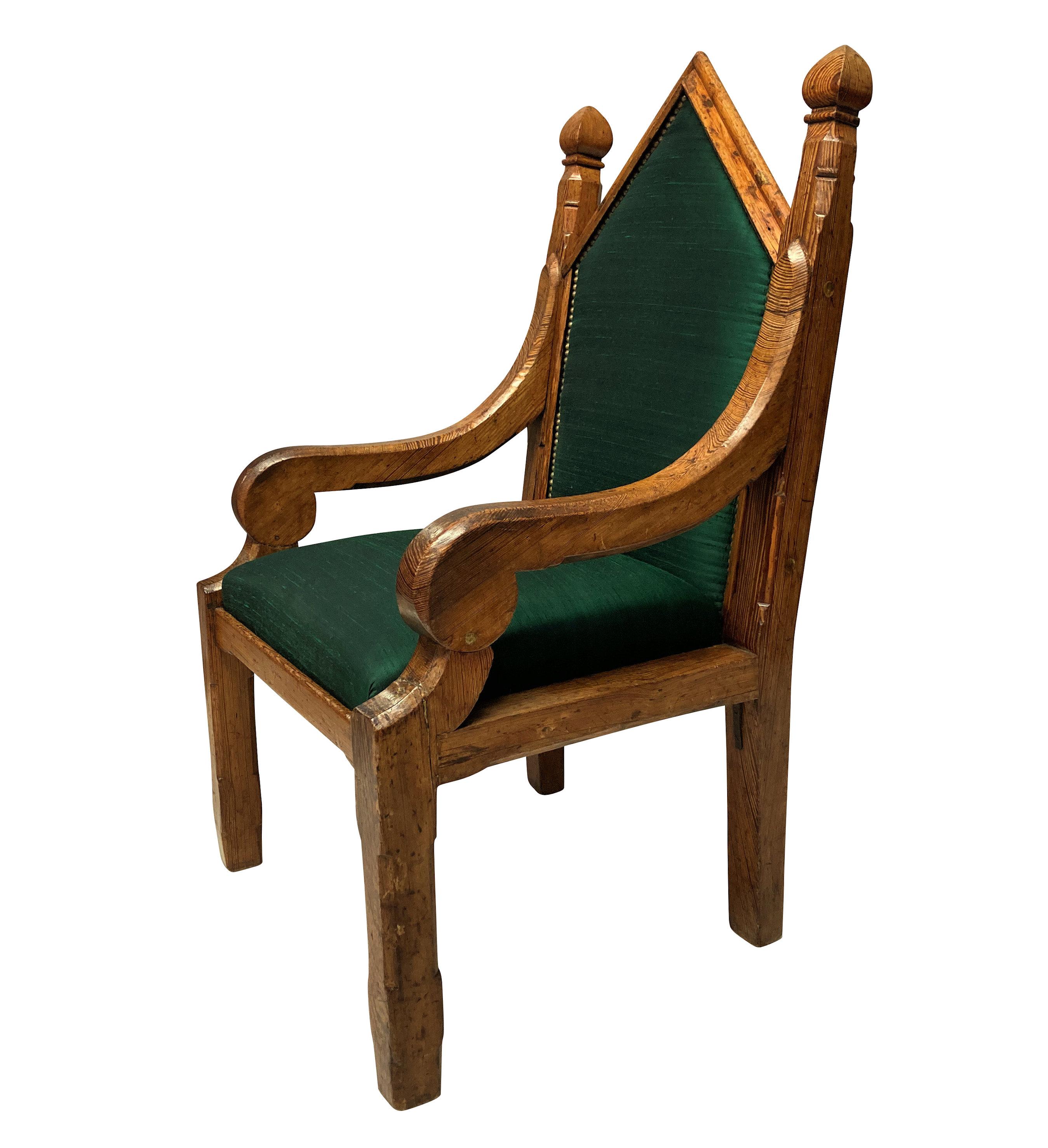An English Gothic armchair of simple design, in pine and newly upholstered in emerald textured silk.
