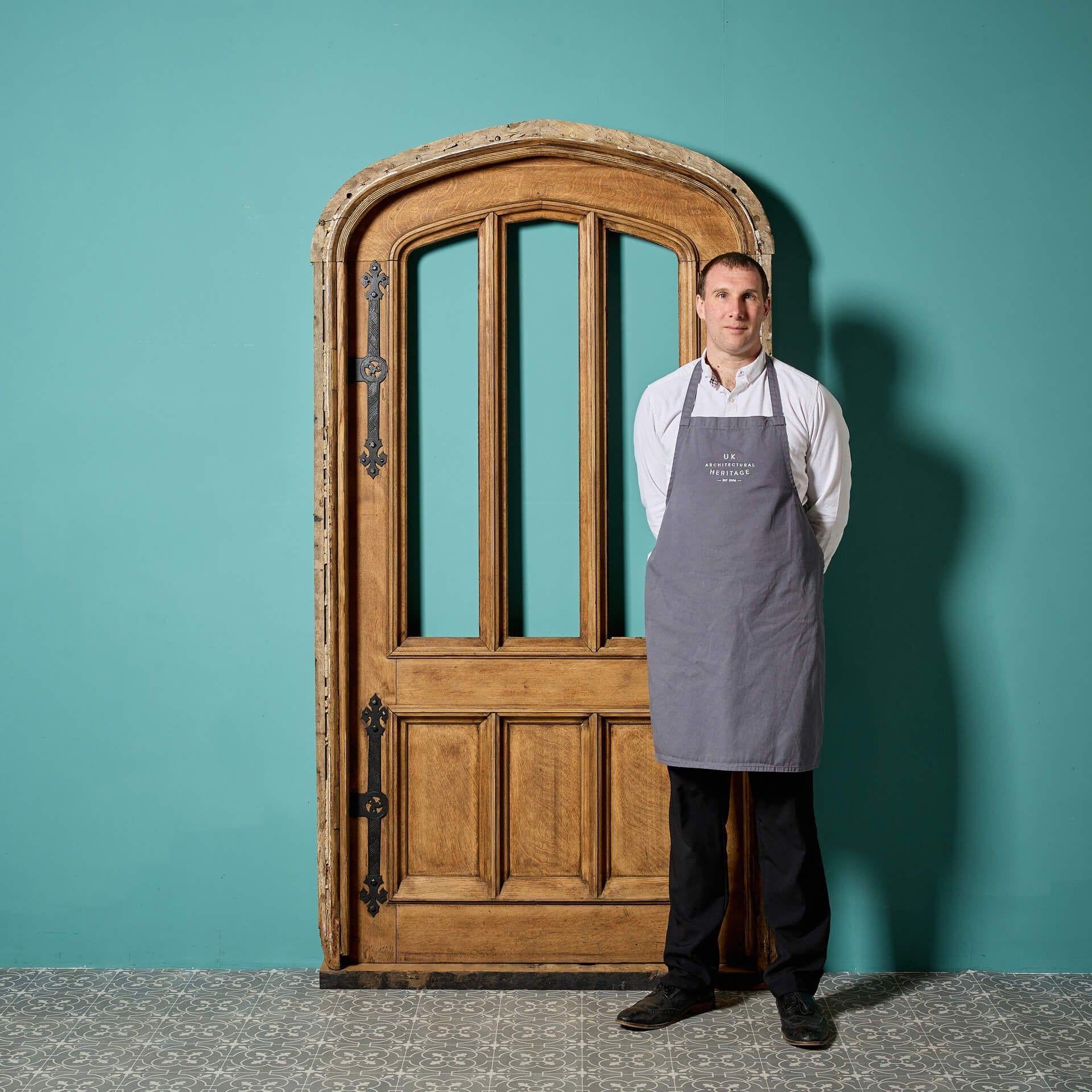 A substantial unglazed solid English oak arched exterior door in the gothic revival style. This door comes without glass, ready from custom-glazing as you desire, and includes a matching oak frame as pictured.

Dating to circa 1880, this antique oak
