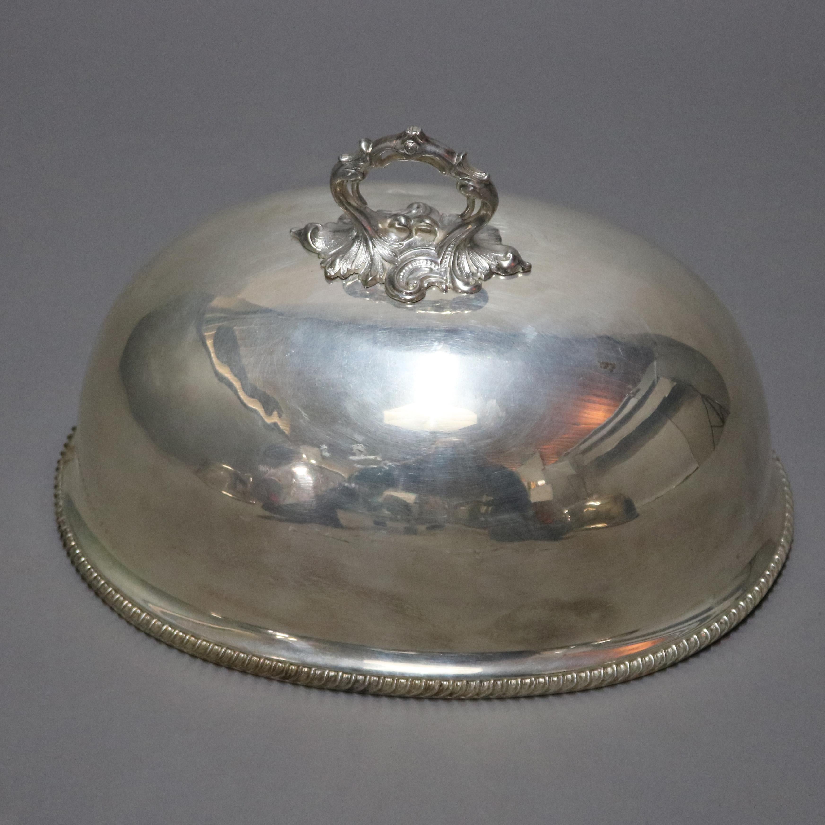 An antique English graduated set of three silver plate Sheffield style cloches, food serving domes, offer foliate form handles and gadrooned trimming, 19th century.

Measures - lg: 11