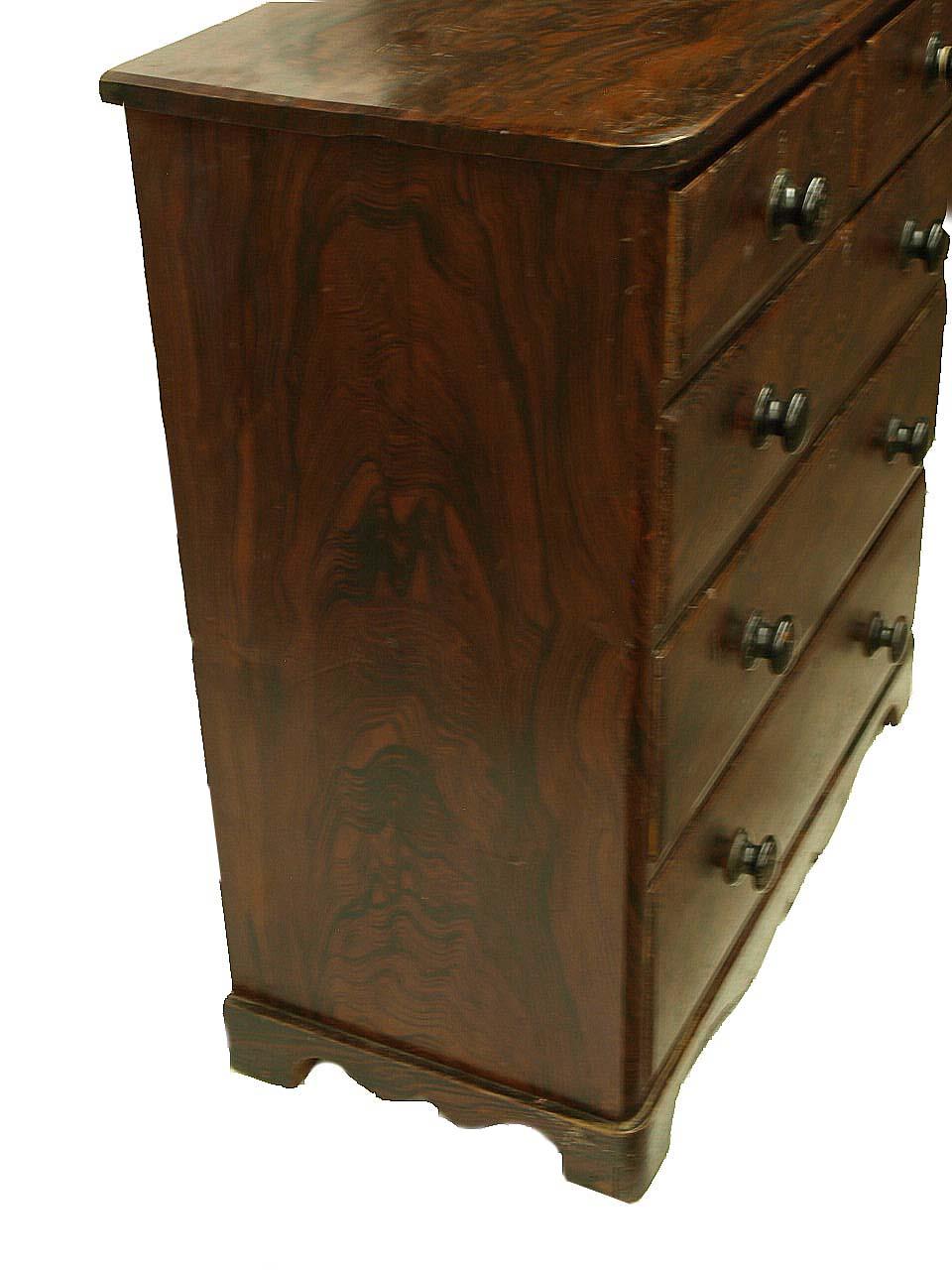 English grain painted chest, the two over three drawers with original wood knobs, the artist using bold design appears to be simulating rosewood. The base has a serpentine shape and is original.
