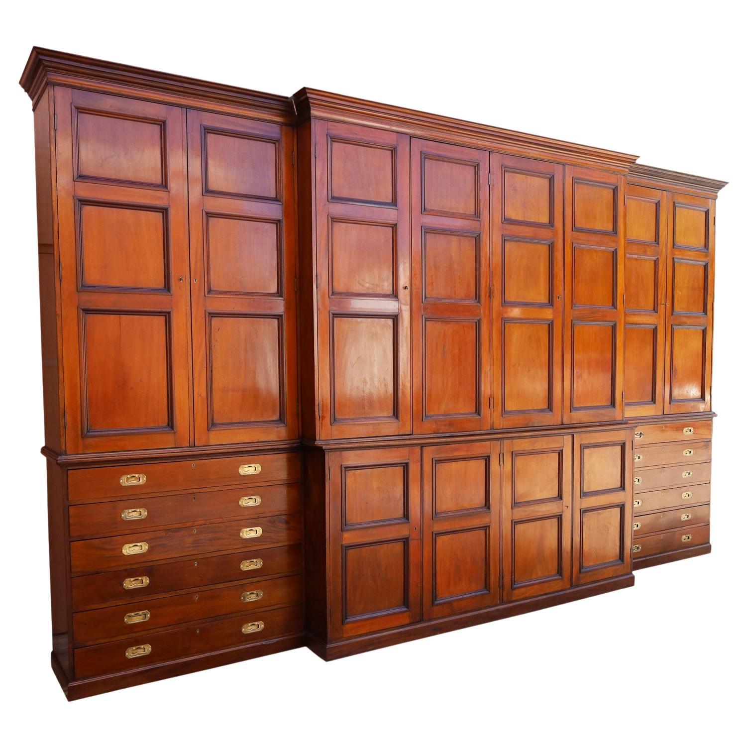 Large and luxurious 19th century English cabinet, wall unit crafted in mahogany with an architecturally significant design, featuring cornices, paneled doors, campaign brass hardware and a block foot. The spacious inside has adjustable pine shelves