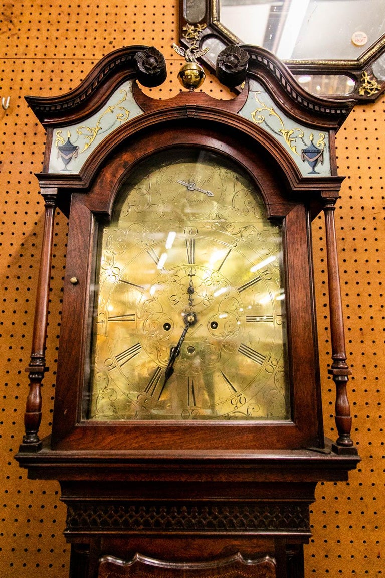 This mahogany grandfather clock was made by Thomas Pringle, St. Ninians, Scotland. There is a finely engraved brass dial with a strike or silent mode. It is engraved with a Mason's compass, rule, and hand saw. The cornice is decorated with rare