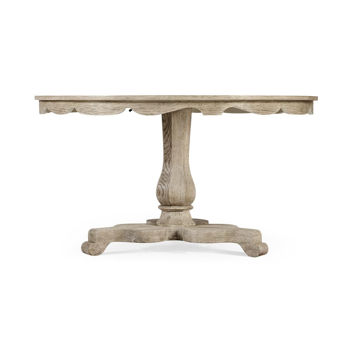 Greyed Oak center or breakfast table with a scalloped apron, on a tripartite baluster form pedestal base.

Dimensions: 54