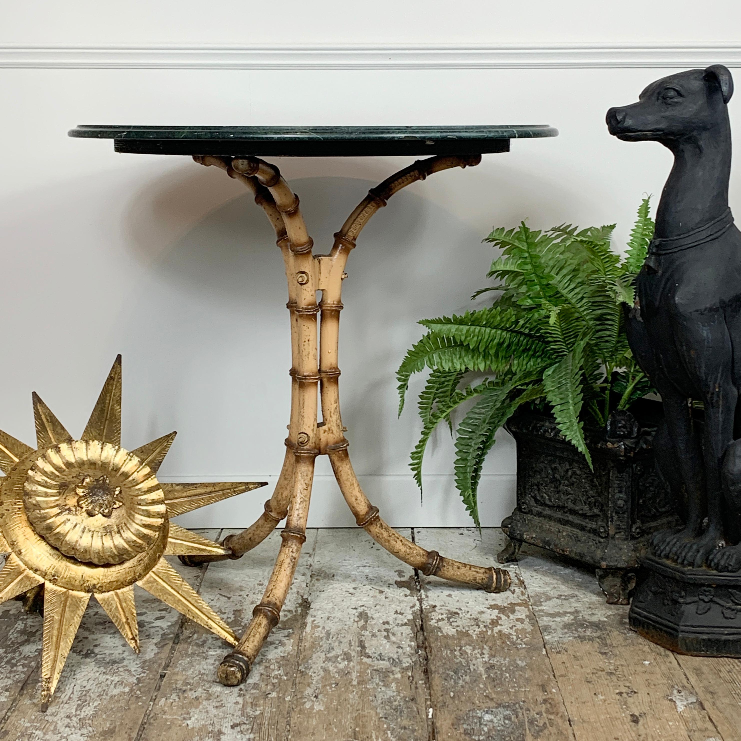 An absolutely beautiful cast iron faux bamboo café table, painted to replicate the look of matured bamboo, this table was made in England in the early 1900’s, is fully stamped to the leg, and has a stunning dark green marble top. 

The marble top