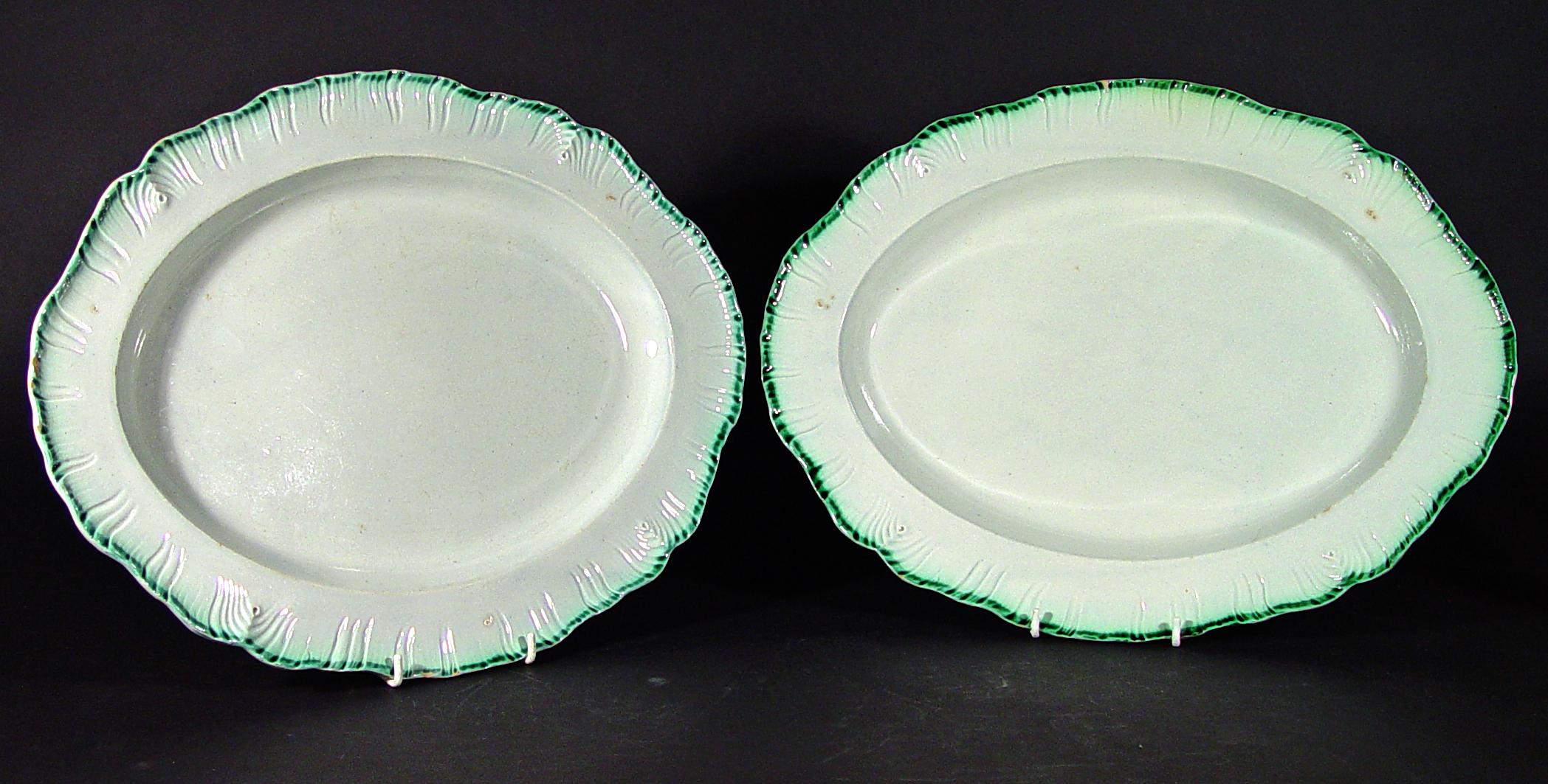 English green shell-edged pearlware pottery dishes, 
Davenport,
circa 1800.

The large oval Davenport dishes are molded with a feathered shell-edge in green glaze.

Dimensions: 16 3/4 inches x 13 inches.