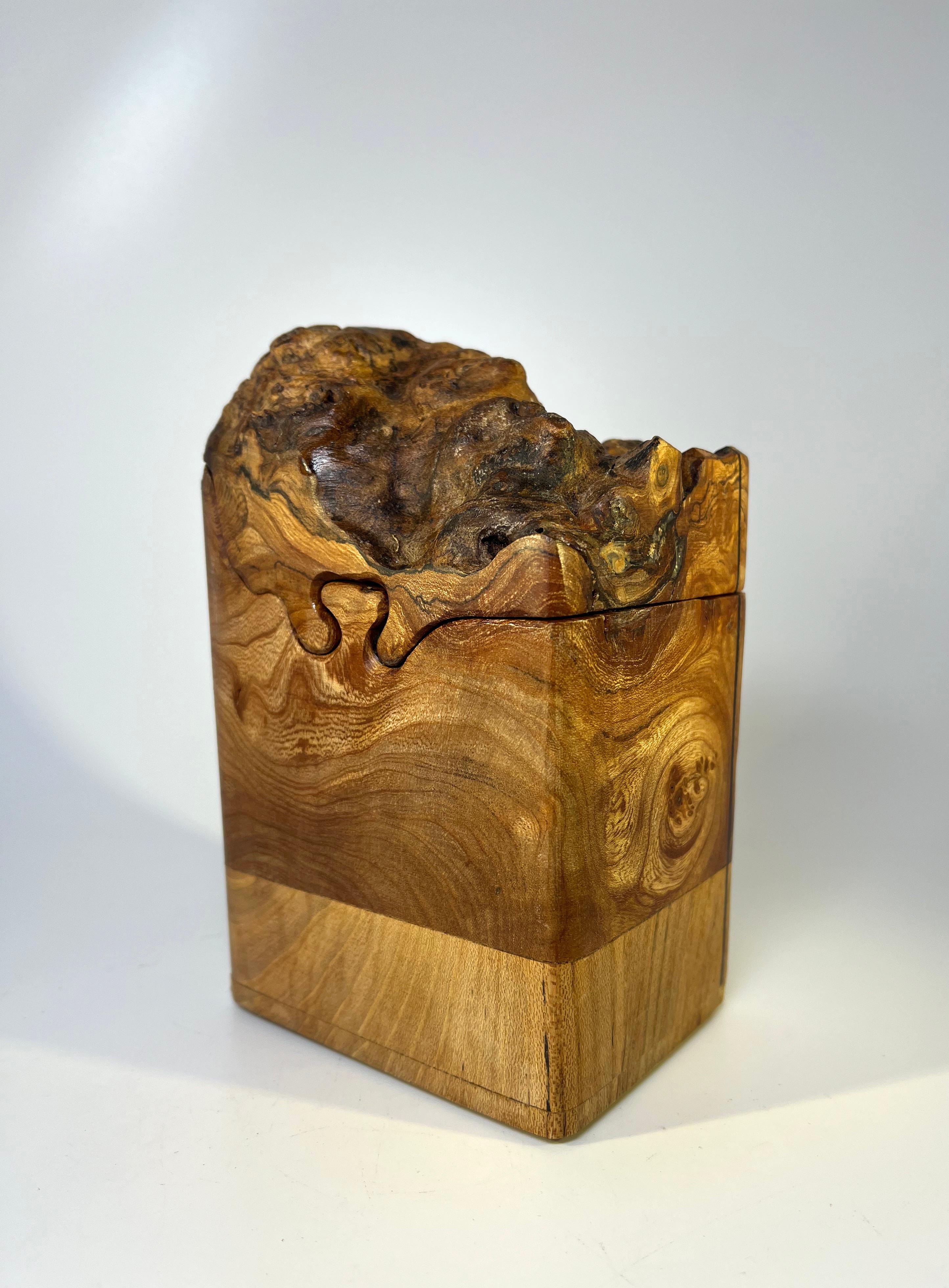 A unique and intriguing desk storage box of hand carved English dark burl elm.
Tactile burr wood lid slides to reveal one storage compartment, and then another 
Superbly created by a fine craftsman.
Circa early 2000.
Measures: height 6.7 inch,