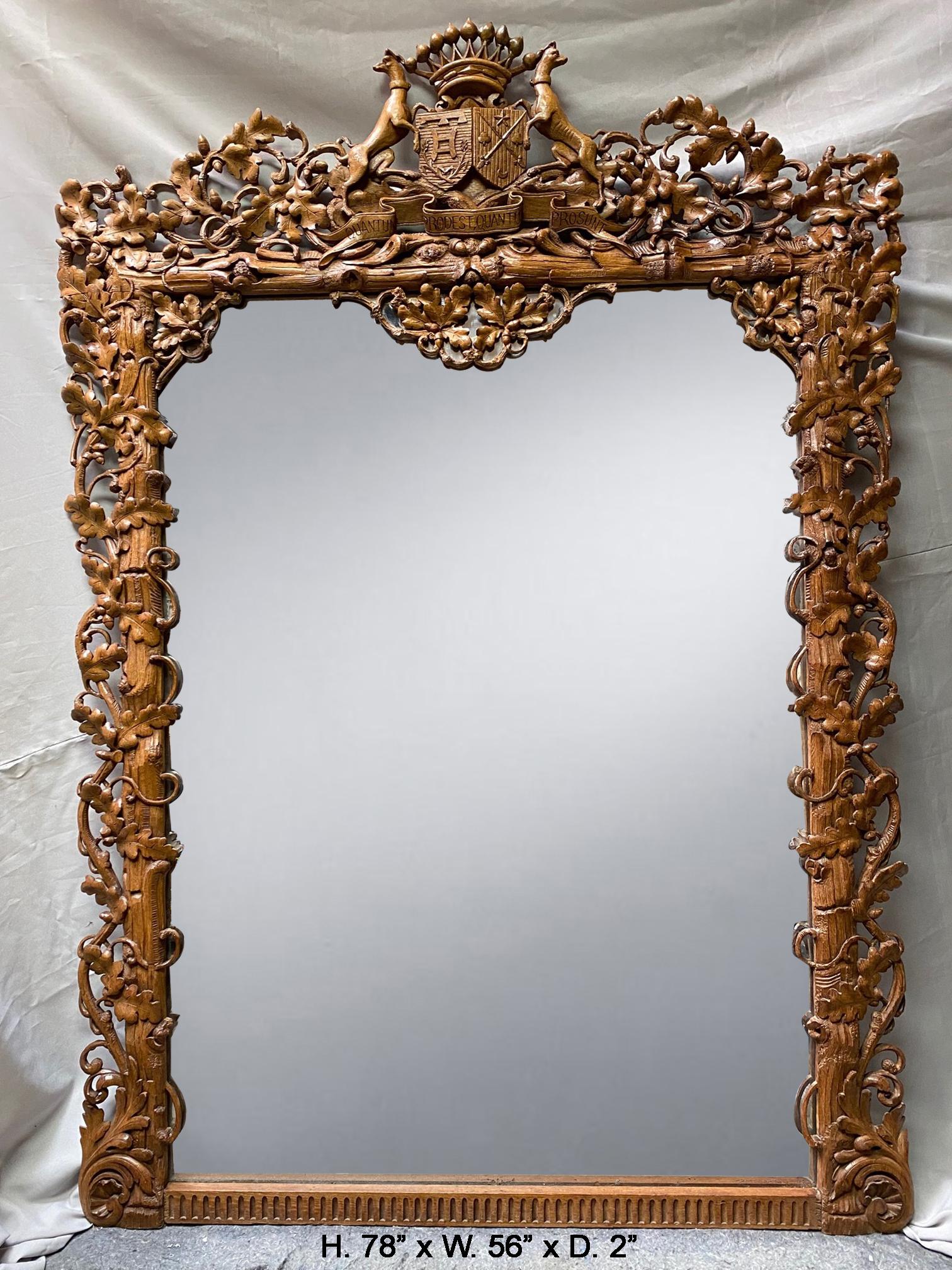 Sensational unique 19th century English hand carved oak mirror
The mirror is surmounted with a hand carved foliate-inspired cresting centered by a coat of arms flanked by two hound dogs and topped with a crown, above the original rectangular mirror