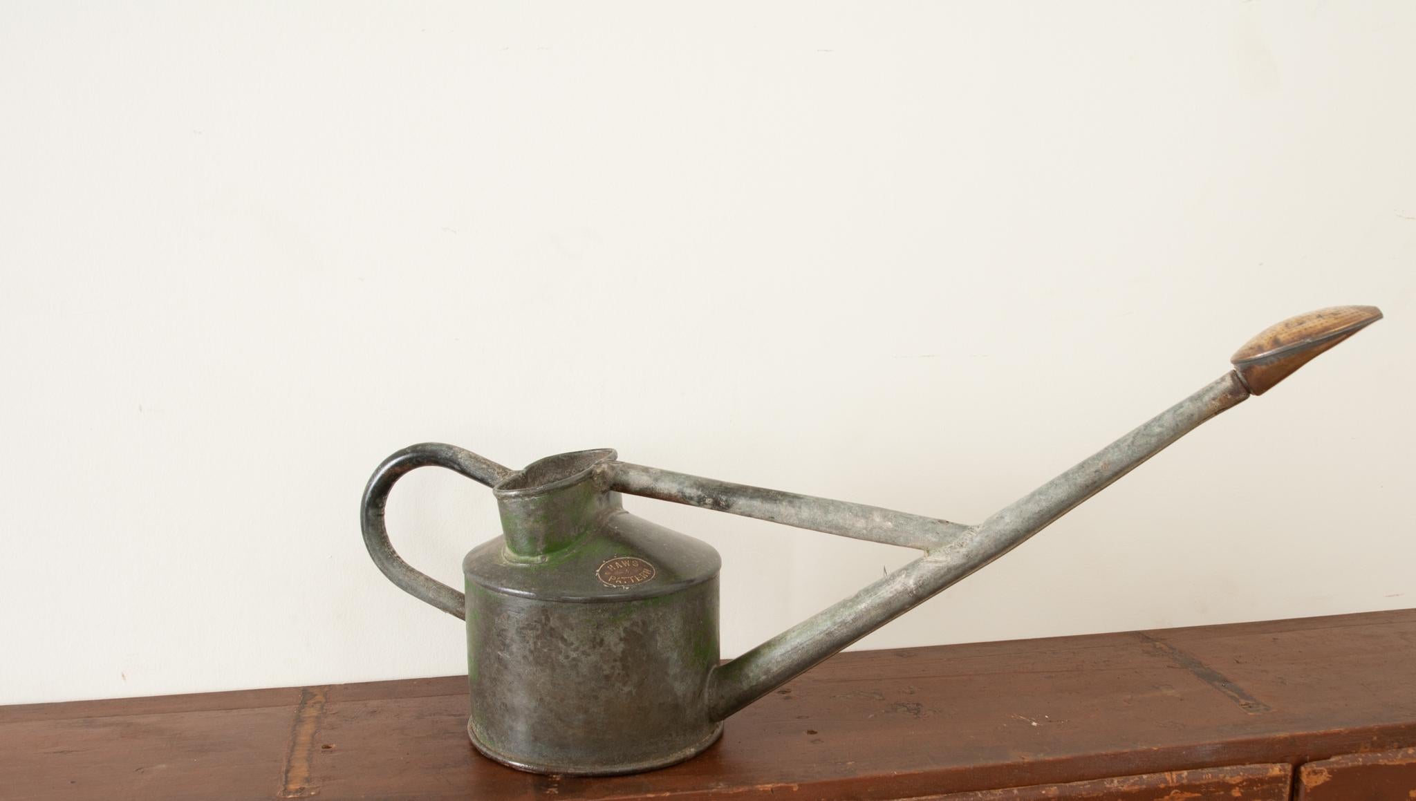 This whimsical English garden antique is just as functional as it is decorative. Crafted from zinc with accents of brass- the whole has gained a great patina. The length of the spout and position of the handle are specifically designed to avoid