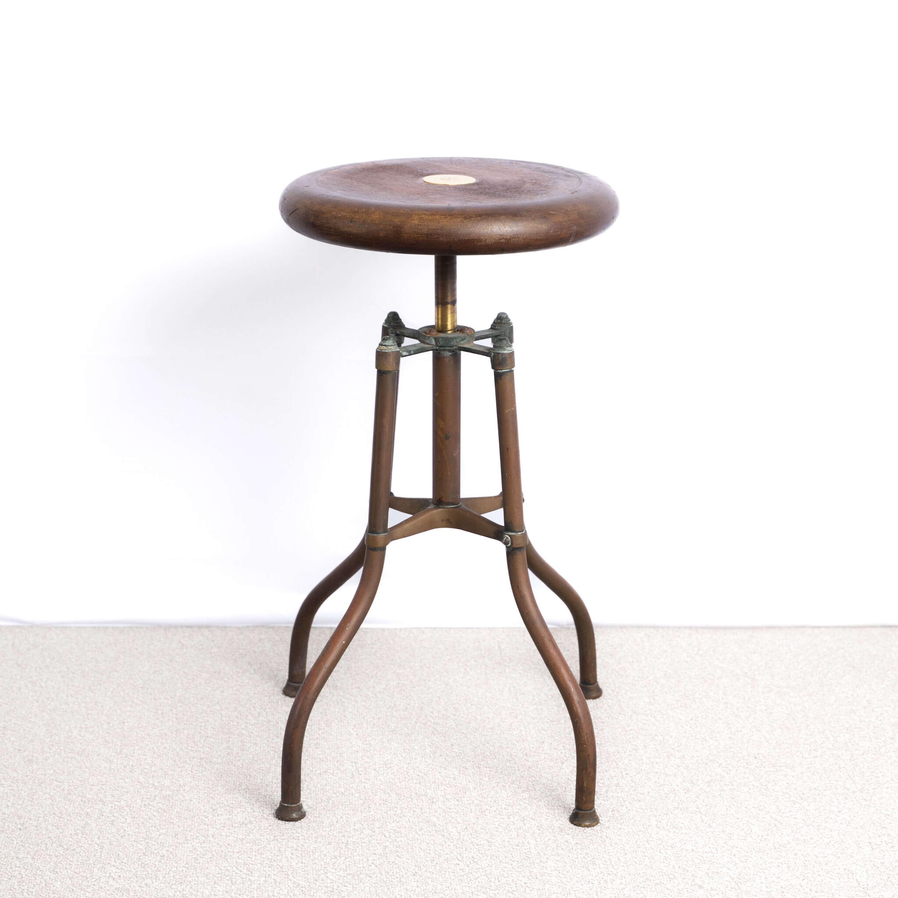 Taburete para piano de altura regulable y giratorio.
Asiento suave y agradable  asiento, estampado por el fabricante, H. Hughes & Son Ltd.
Hughes and Sons eran originalmente relojeros del East End de Londres que más tarde suministraron sextantes y