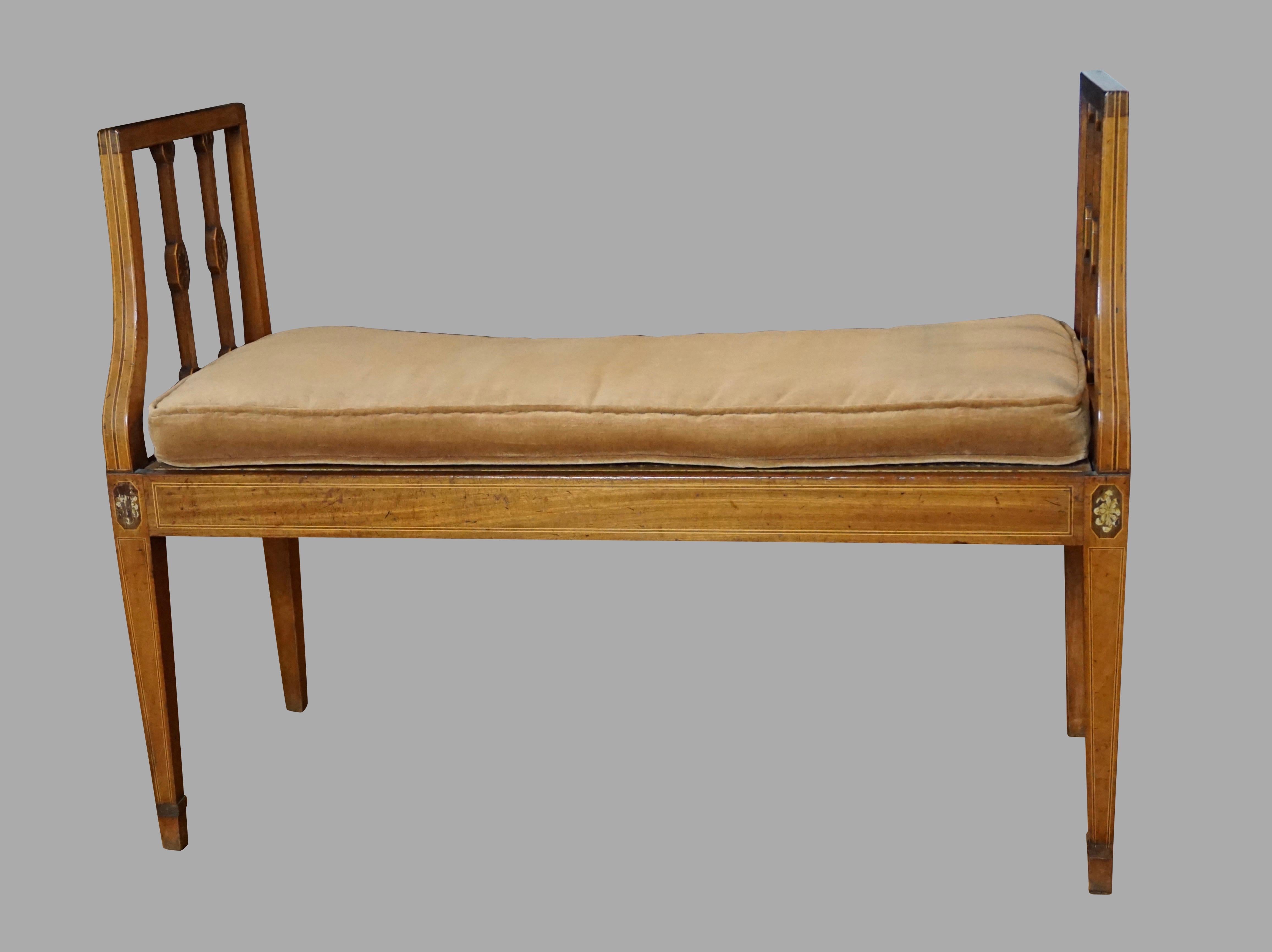 An elegant English mahogany line inlaid Hepplewhite period window seat with a caned deck, the square tapering legs headed with floral inlaid decoration, the side stiles similarly done. Comes with a later upholstered cushion. Circa 1790. Provenance: