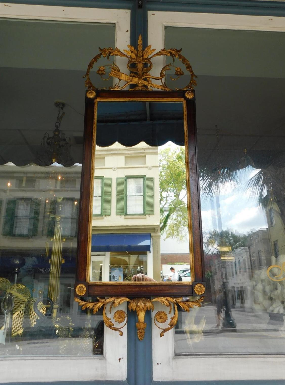 English Hepplewhite mahogany and gilt wood scrolled acanthus foliage wall mirror with central quiver and arrows, flanking corner medallions, and interior bead work, Late 18th century. Mirror retains the original silvered glass and backing.