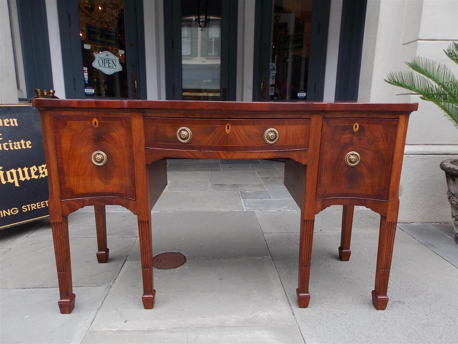 English Hepplewhite mahogany serpentine sideboard with a cross banded top, satinwood and ebony inlaid checkering, centered bowed felt line drawer for silver, flanking cross banded inlaid cellarette drawers, period brasses with inlaid oval diamond