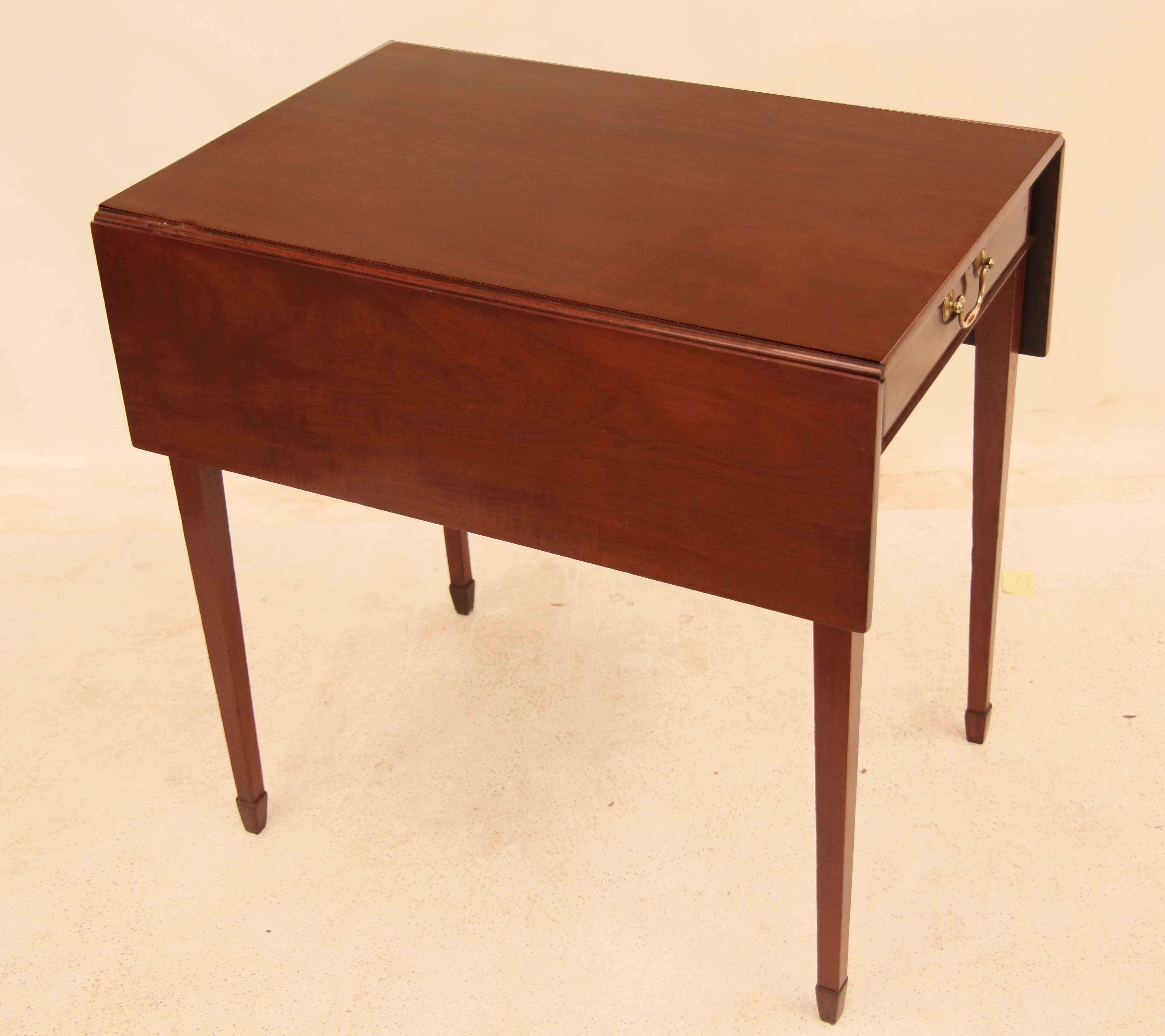 English Hepplewhite pembroke table, the top and leaves with rich mahogany color and patina; single drawer with swan neck brass pull. The tapered legs terminate with spade feet. Of note, the leaves are held up by double 
