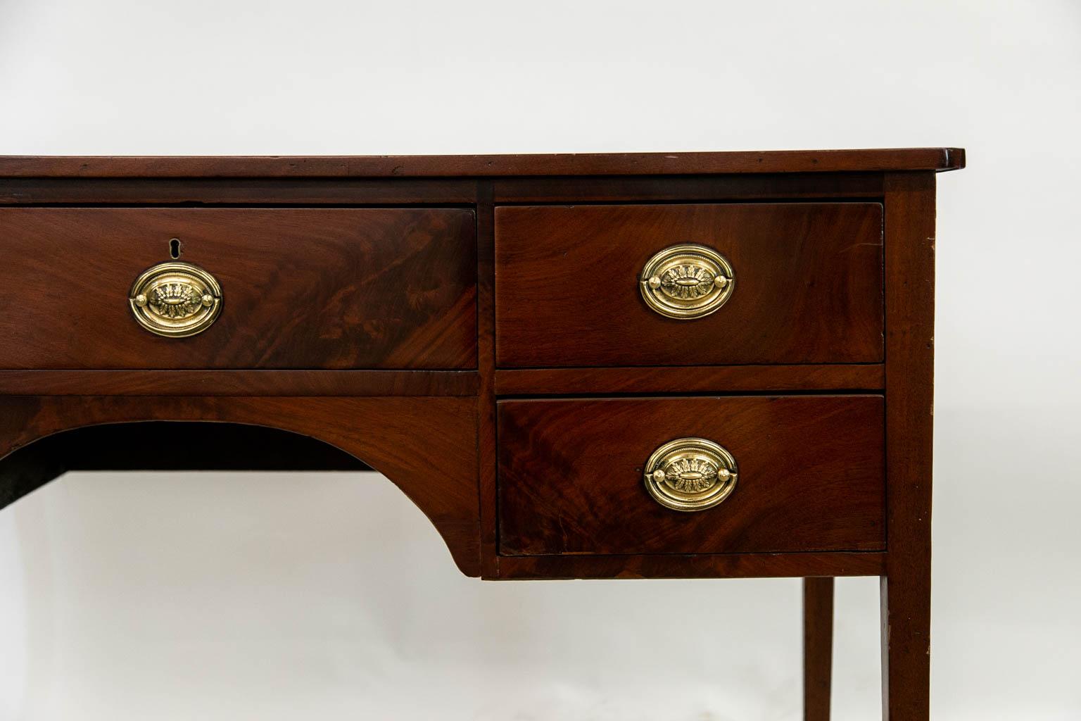 The drawer fronts of this server are flame grain mahogany. The lock is original and brasses are later. The front and sides are banded with a strip of mahogany.