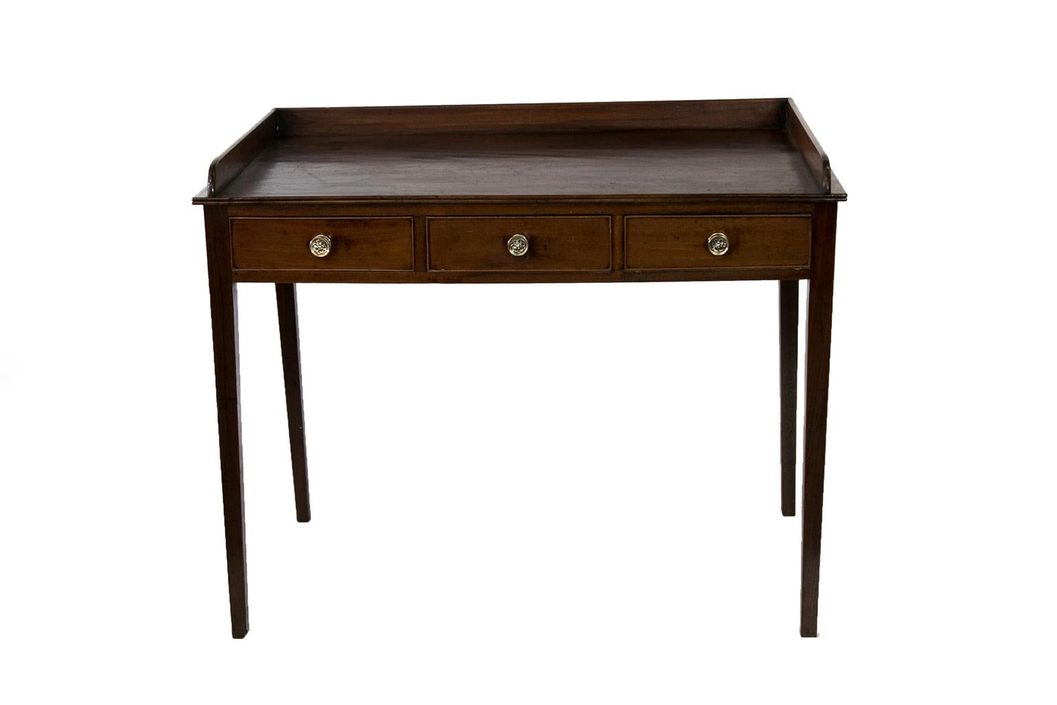 The top of this English Hepplewhite serving table has a gallery on three sides, this would also make an excellent small writing table. There is some minor surface scratching and stains commensurate with age and use, along with a very pleasant color