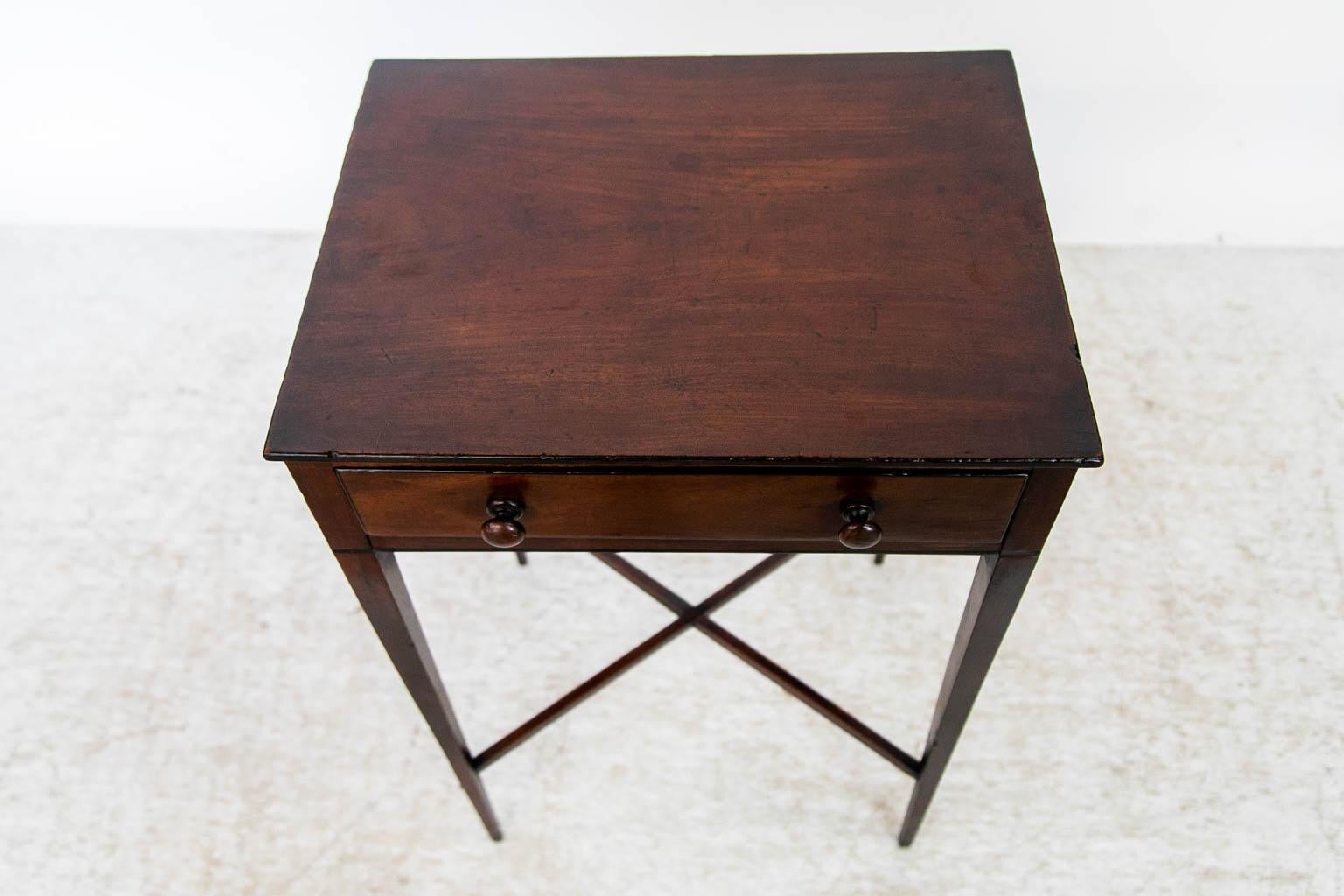 This Hepplewhite mahogany table is finished on all four sides and has an ebony band below the drawer which traverses all four sides. The drawer has the original dividers and ebony edging on the front. The legs are joined by an 