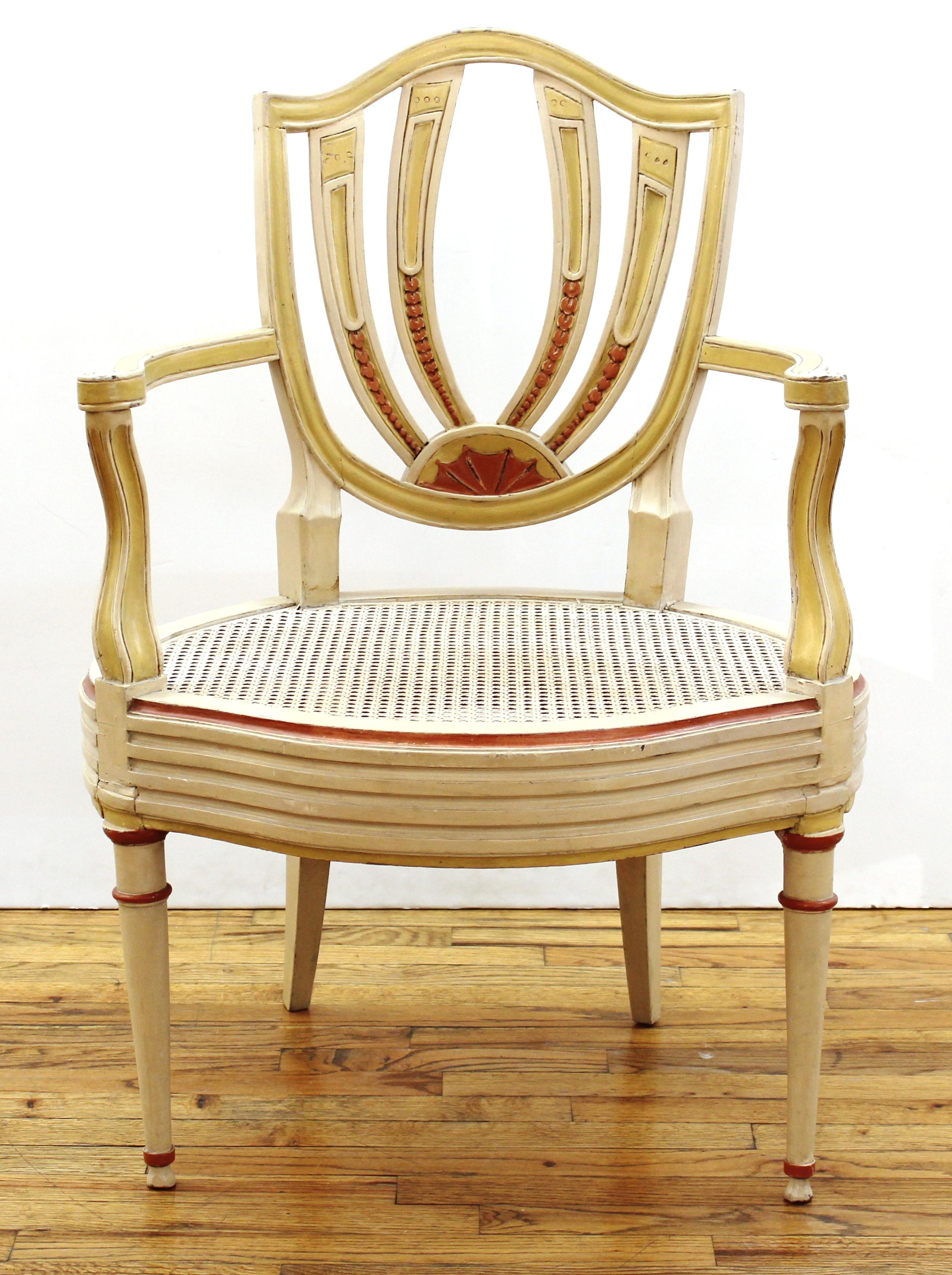 English Hepplewhite style pair of antique shield back paint decorated armchairs with caned seats. Old Sotheby's auction tags and labels on the bottom. Measures: 38