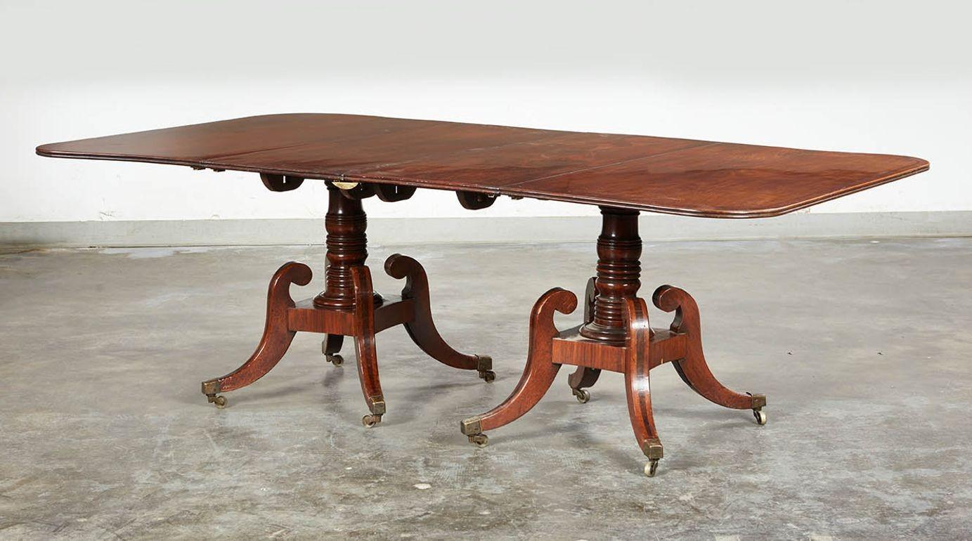 A period high style Regency dining table in the choicest padouk wood. Each leaf and top is made of a single plank of padouk, reserved for only the best furniture, further inlaid with rosewood in a decorative pattern, with eased corners and a reeded