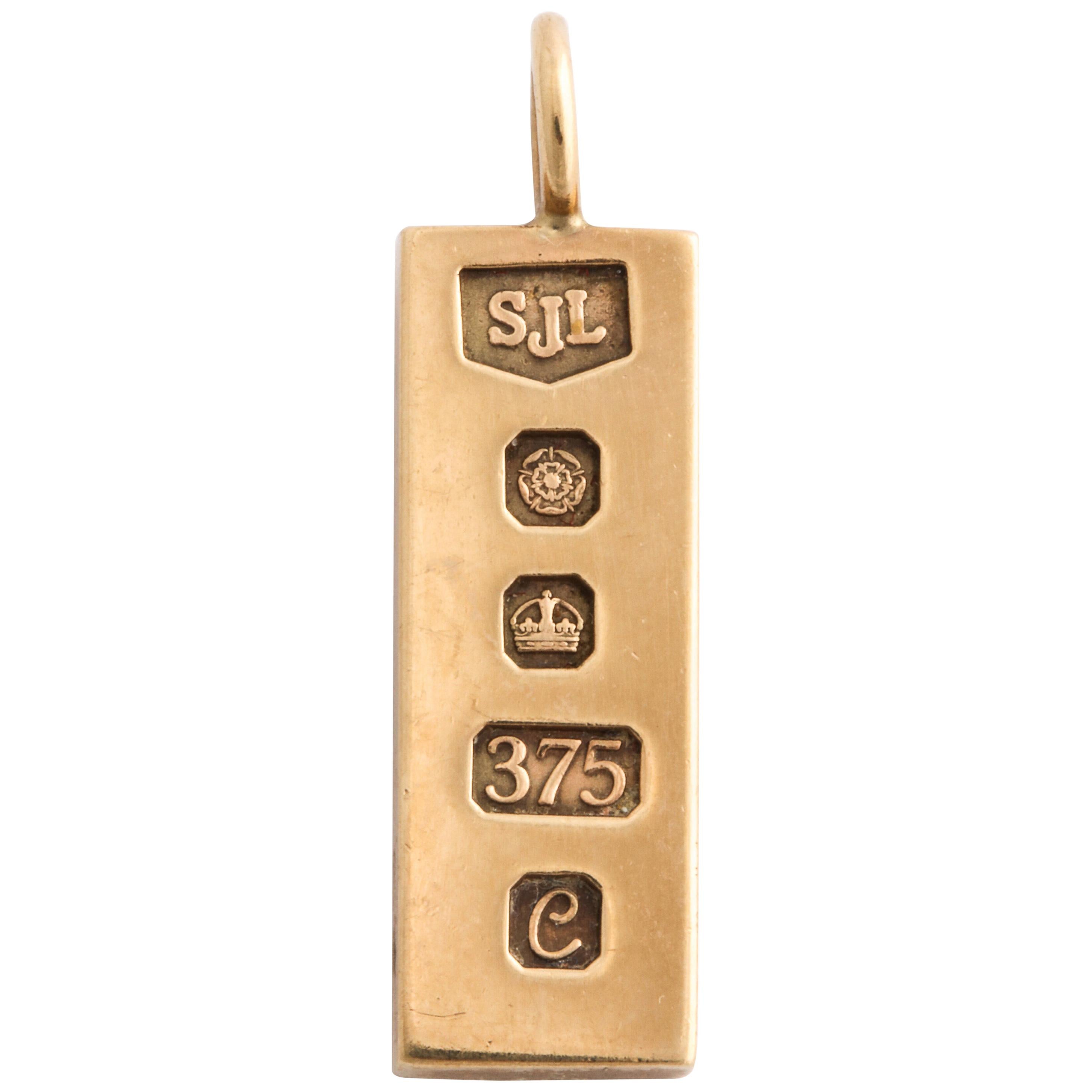 Of polished 9k gold, the ingot stamped with English hallmarks, a rose for the town of Sheffield, the date letter e for 1977, 375 for 9k, a crown and maker’s mark SJL, with circular suspension ring.

1 ¼ in. (3.2 cm) long including ring; 3/8 in. (