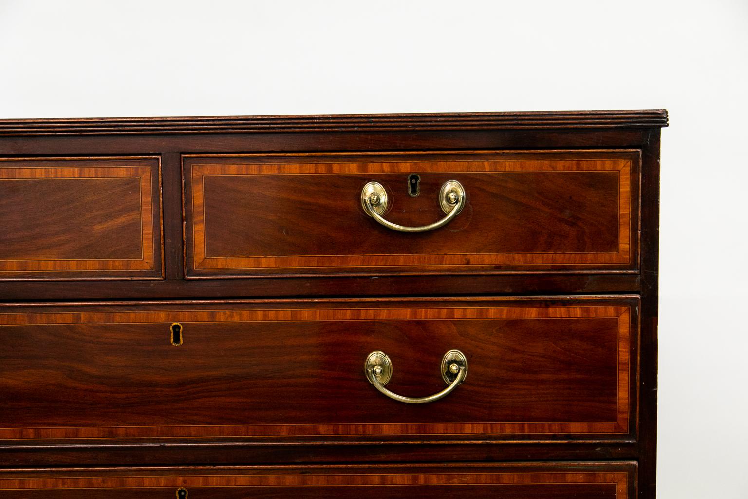 The top and drawer fronts of this chest are inlaid with a band of bee's wing satinwood framed by ebony and boxwood lines. There are two indentations in the surface of the front right corner.
