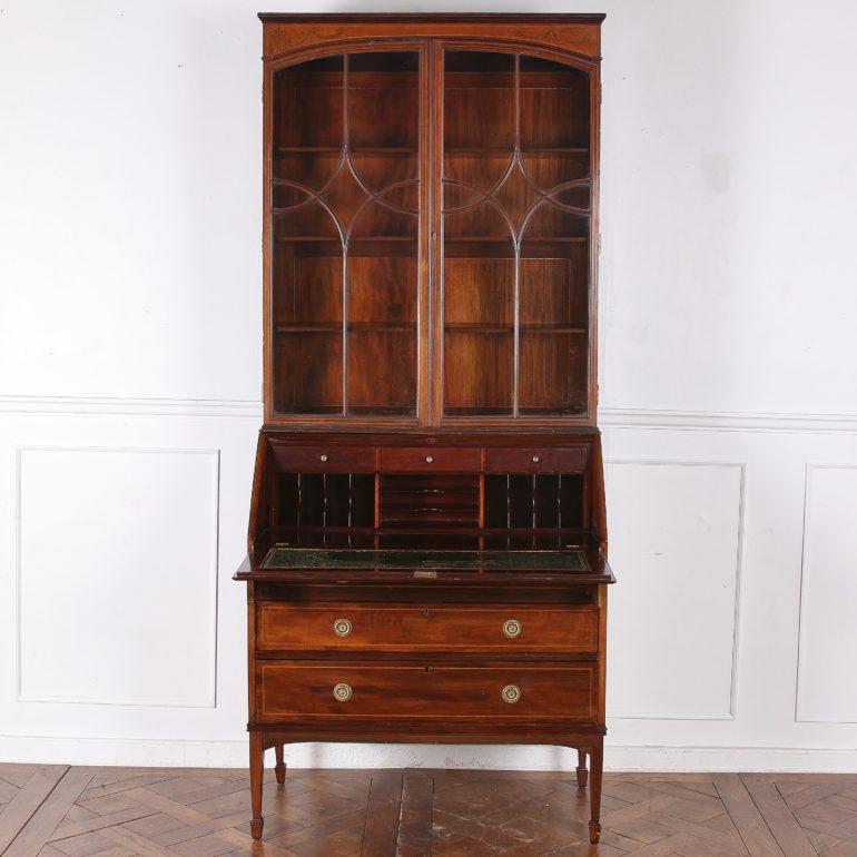 English Edwardian inlaid mahogany secretary bookcase, the case featuring boxwood inlay of ribbons and swags. Nicely-fitted interior with three drawers and a leather writing surface. 

Measures: 36.5 inches wide x 19 inches (closed) x 32 inches