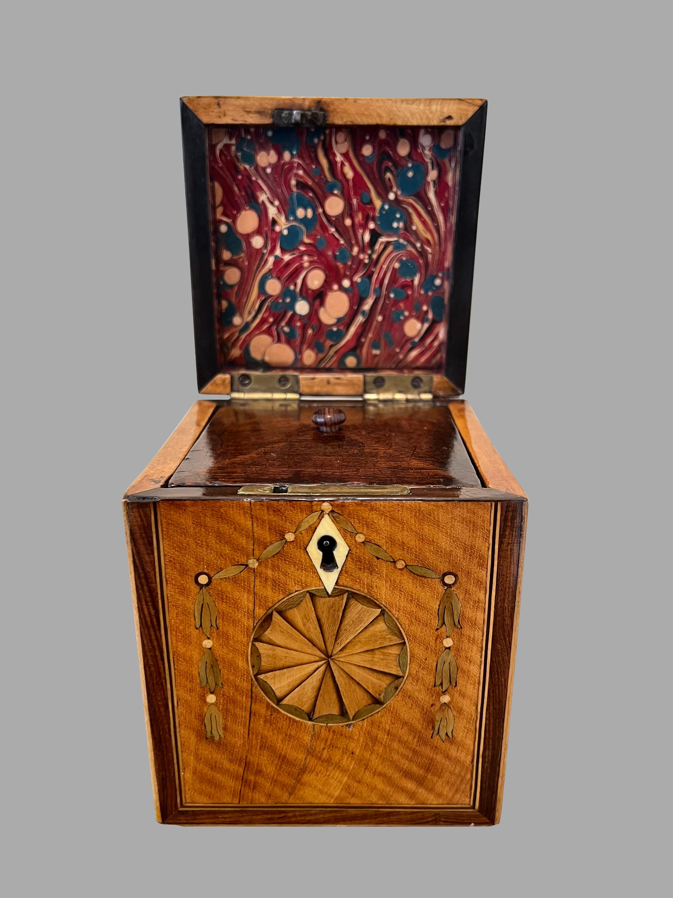 An extremely fine quality inlaid mahogany tea caddy of elegant small size, the top and front with elaborate crossbanding and circular fan inay, the front with further swag inlay, the interior retaining its original top. A great example of English