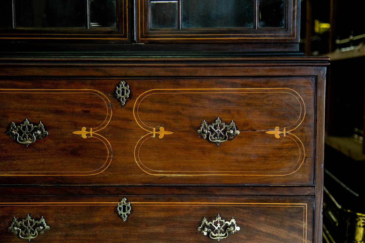 This secretaire is inlaid throughout with boxwood line inlay with two satinwood fans in the broken arch crest. The top half has two fixed shelves. There are some shrinkage separations in the back. The right hand side of the secretaire pull out