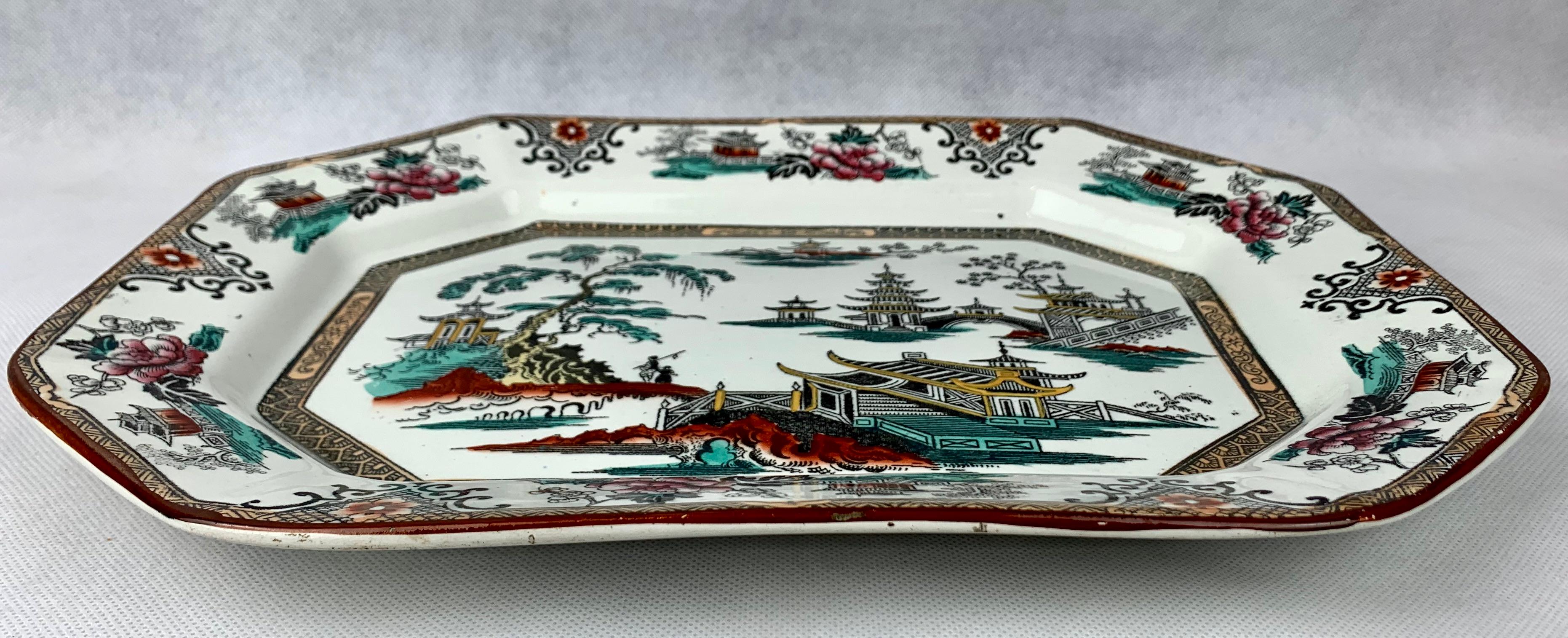 English Victorian cut corner ironstone platter with charming chinoiserie scenes. Transfer printed in black and then overpainted with color. The over painting was done with turquoise, rosy reds and iron red, while the border was over painted with