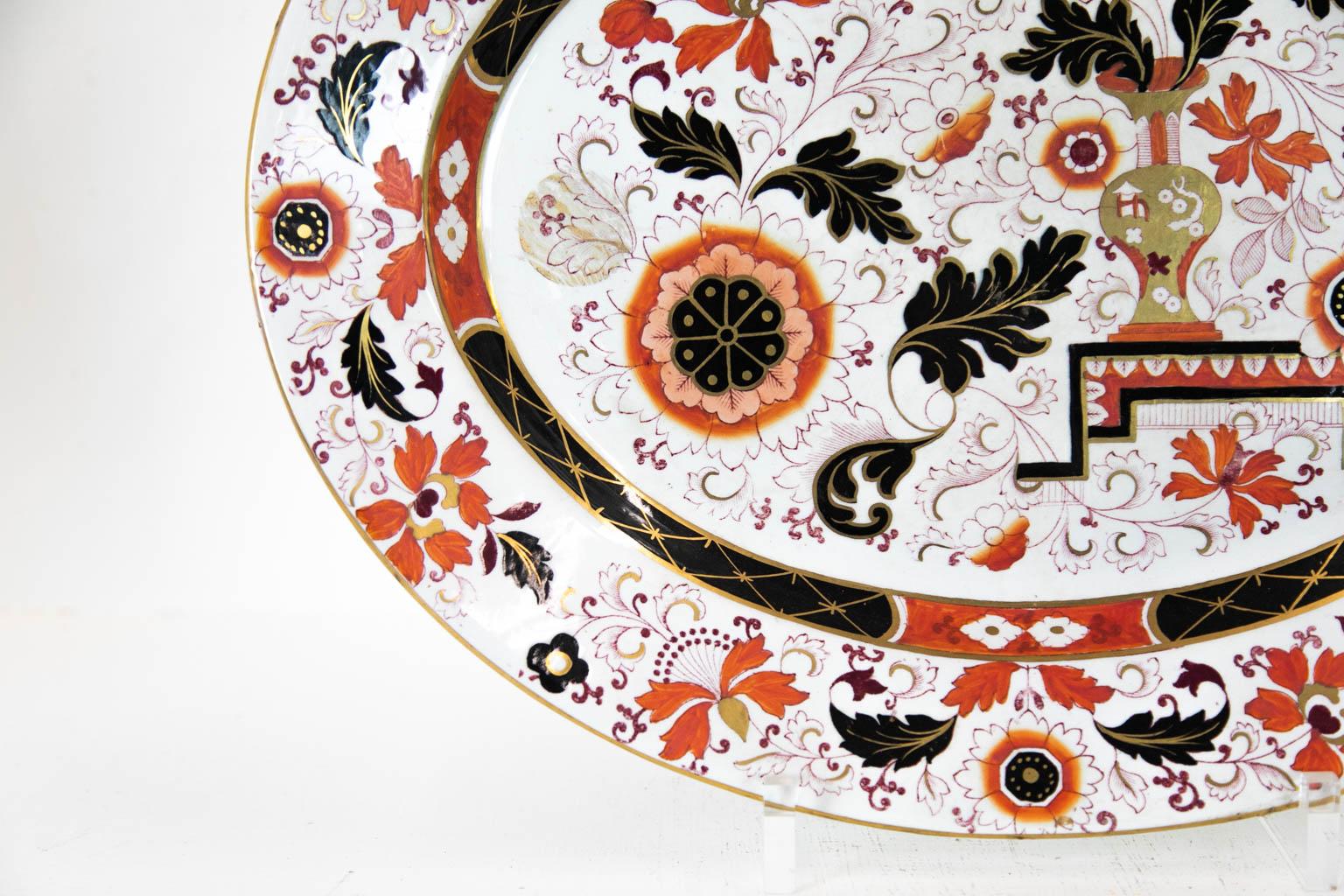 This platter is signed: Ashworth Ironstone. It has gilt floral designs with vases, leaves, and flowers. It is in mint condition.