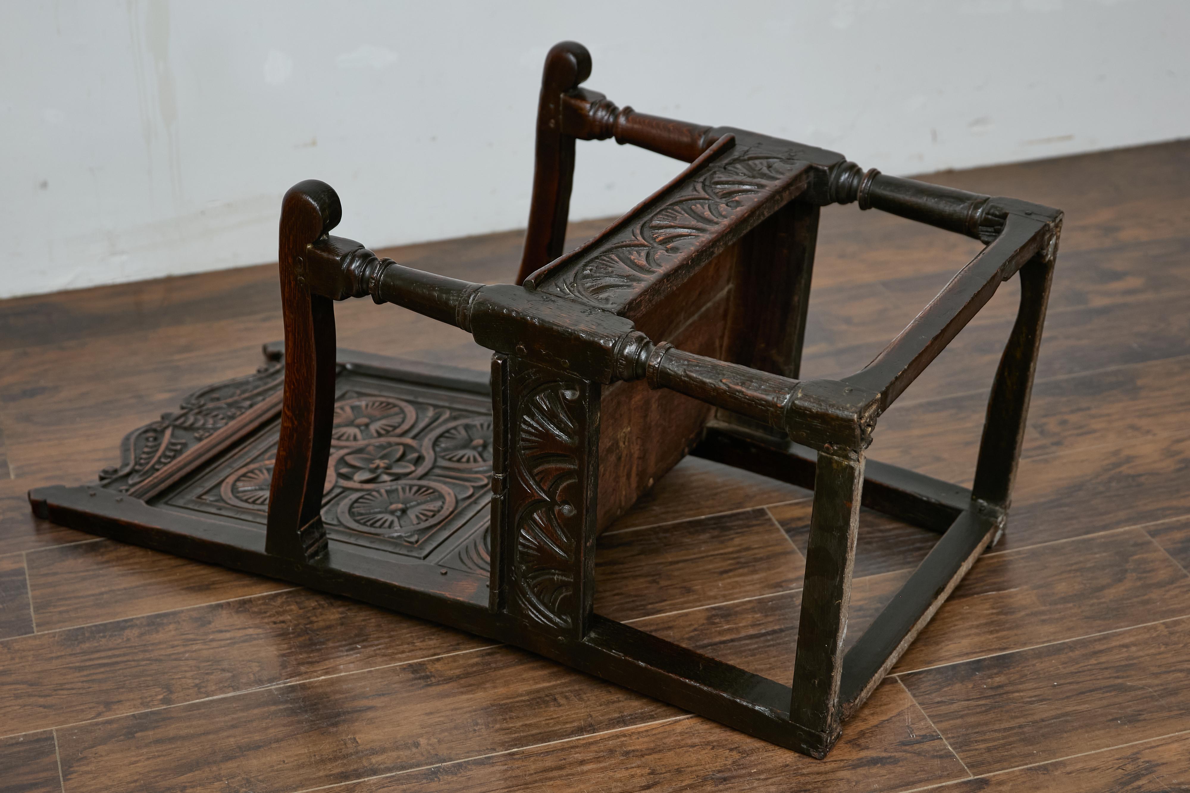 An English Jacobean oak high back armchair from the late 17th century with carved décor. This English Jacobean period oak chair from circa 1690 is a stunning example of the craftsmanship and design from the early 17th century. With its intricate