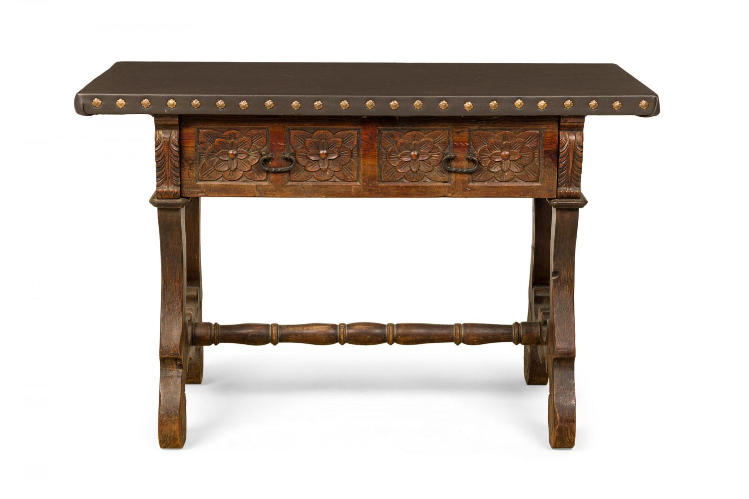 English Jacobean-style (20th Century) carved mahogany console table with a dark gray leather top with decorative nailhead trim above three drawers with floral design carved fronts flanked on either side with carved acanthus leaves, resting on four