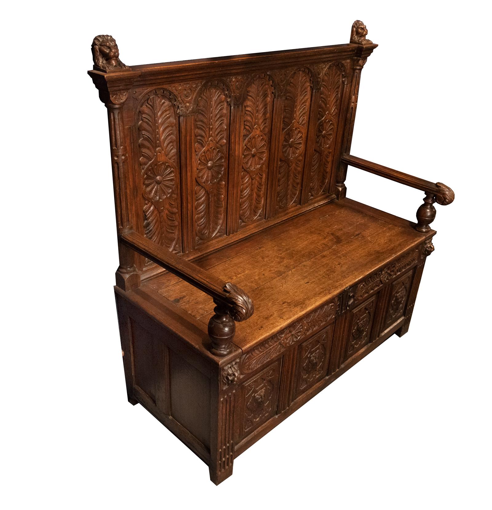A carved oak hall bench created in England during the 19th century using older elements salvaged from period furniture. Designed to emulate the designs of early 17th century furniture. The seat hinges to reveal a storage compartment.

Measures:
