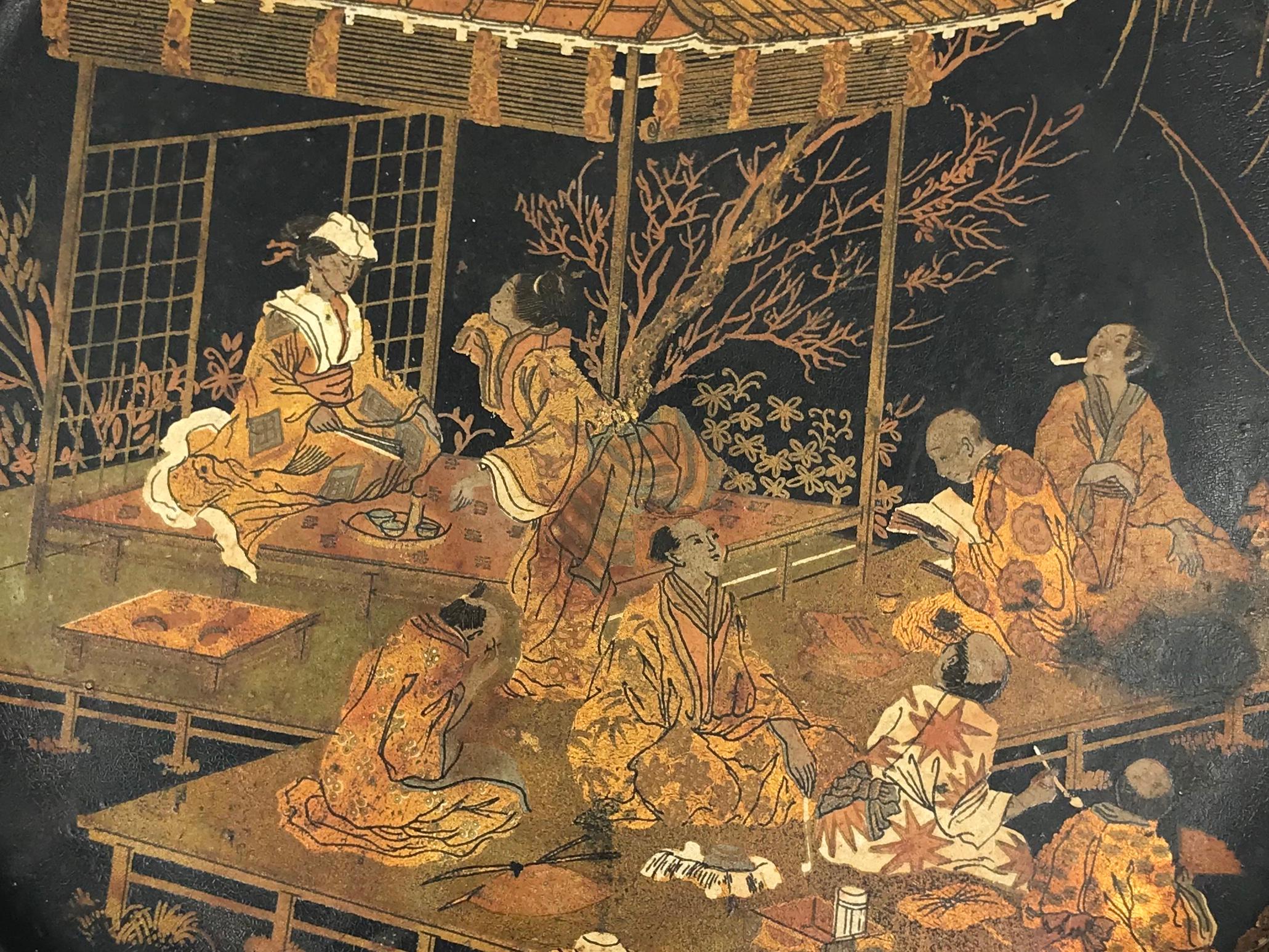 Bandeja redonda japonesa inglesa. Antigua bandeja redonda de papel maché japonado con figuras cortesanas en un pabellón con pájaros en dorado y blanco sobre fondo negro. Inglaterra, finales del siglo XIX
Dimensiones: 8,13