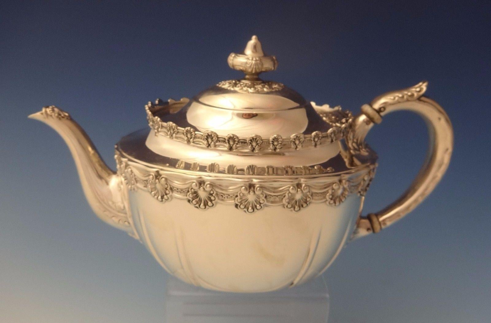 English King by Tiffany & Co. English King by Tiffany & Co. 3-piece sterling tea set. The pieces are marked with a T date letter for 1892-1902 and #9579/5465. The pattern features a border of detailed shells. The set includes:
Tea pot: Holds 2 1/2