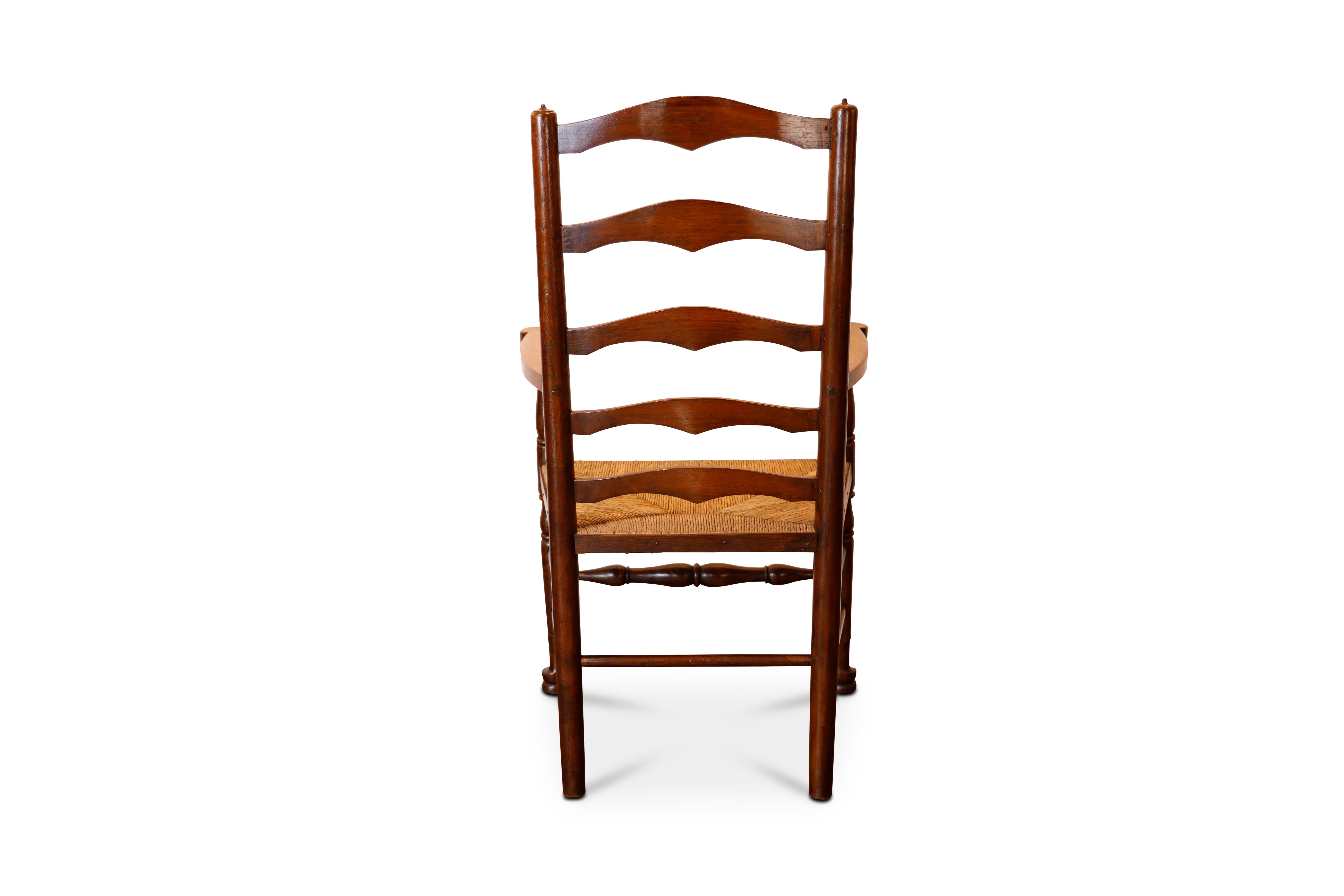 Late 19th c. English oak ladder back chairs with rush seats and turned stretchers.   2 arms, 6 sides.