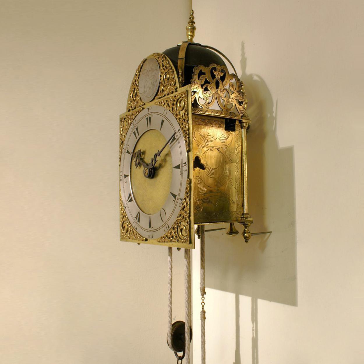 A fine 18th century English brass and iron lantern clock. Signature: William Kipling, London The clock consists of going and striking trains, as well as an alarm and is driven by lead weights. The front fret is richly decorated. The corners and the