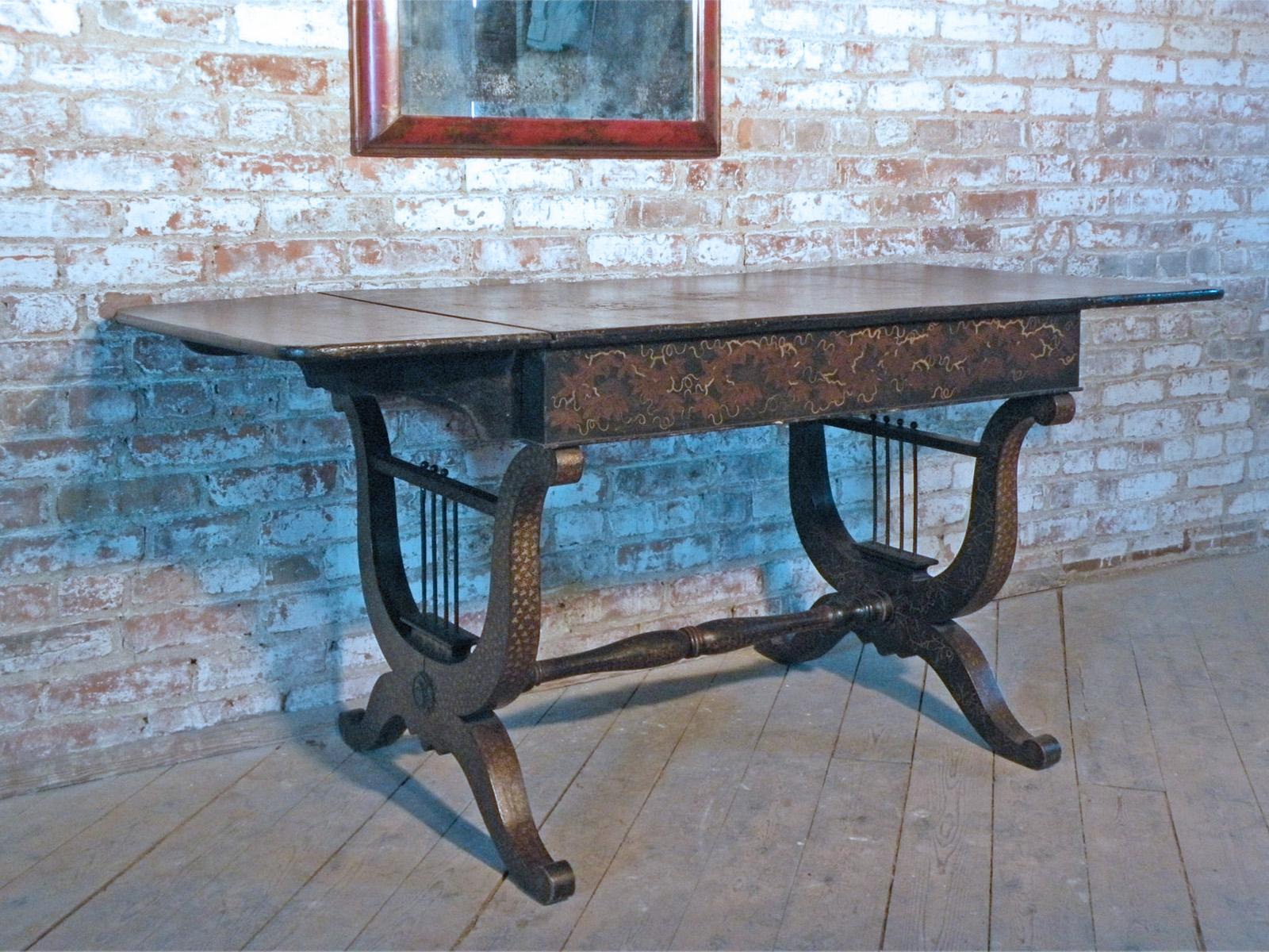 Unusual 19th century late Regency sofa table with black chinoiserie lacquer decoration. The top with drop-leaves on each end, above Lyra form supports joined by center stretcher.