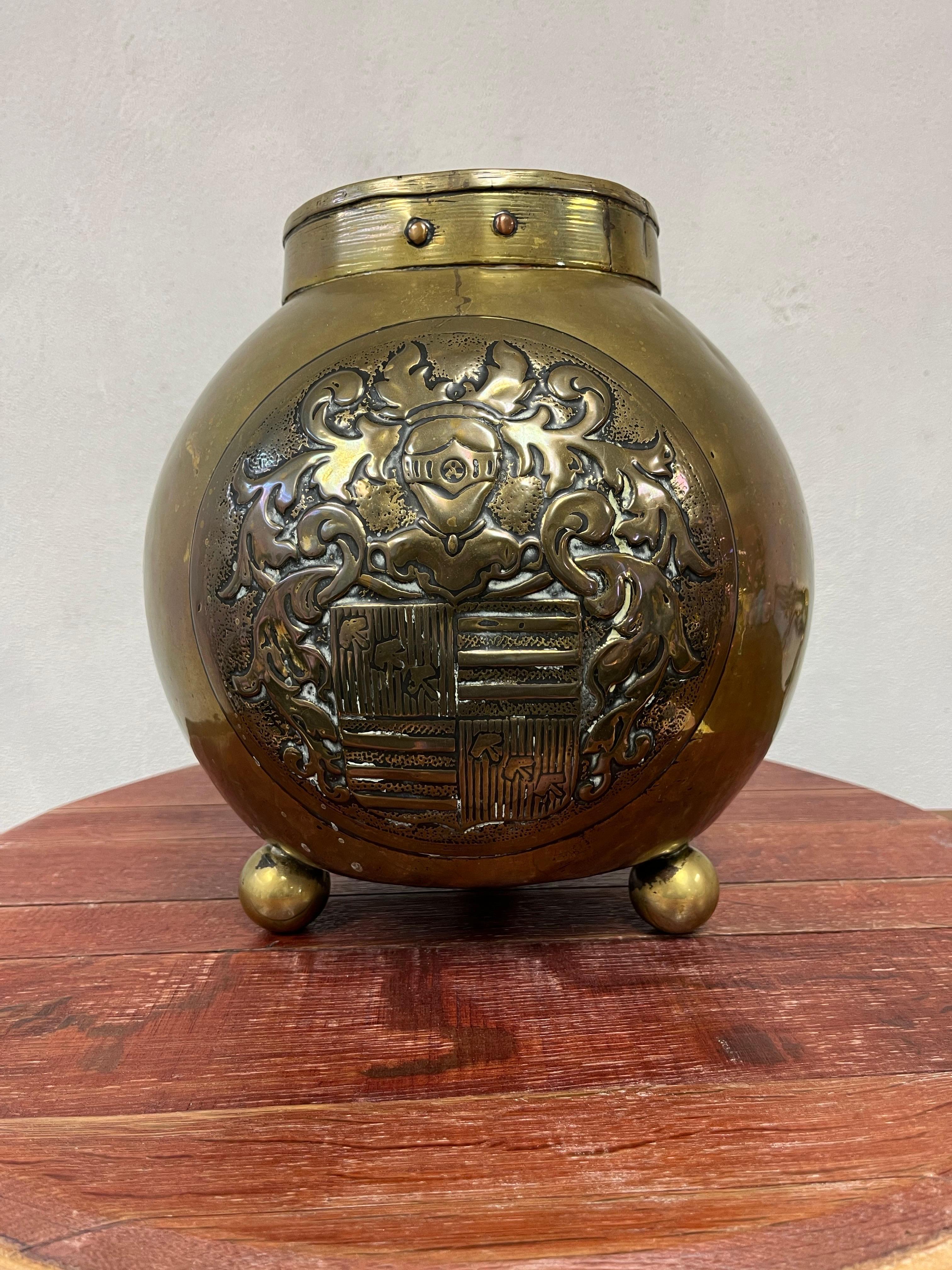 Beautiful heraldic brass and copper pot. deep detail in shield and quality craftsmanship throughout. Offset bronze rivets around rim. Heavy ball feet. Nicely scaled.