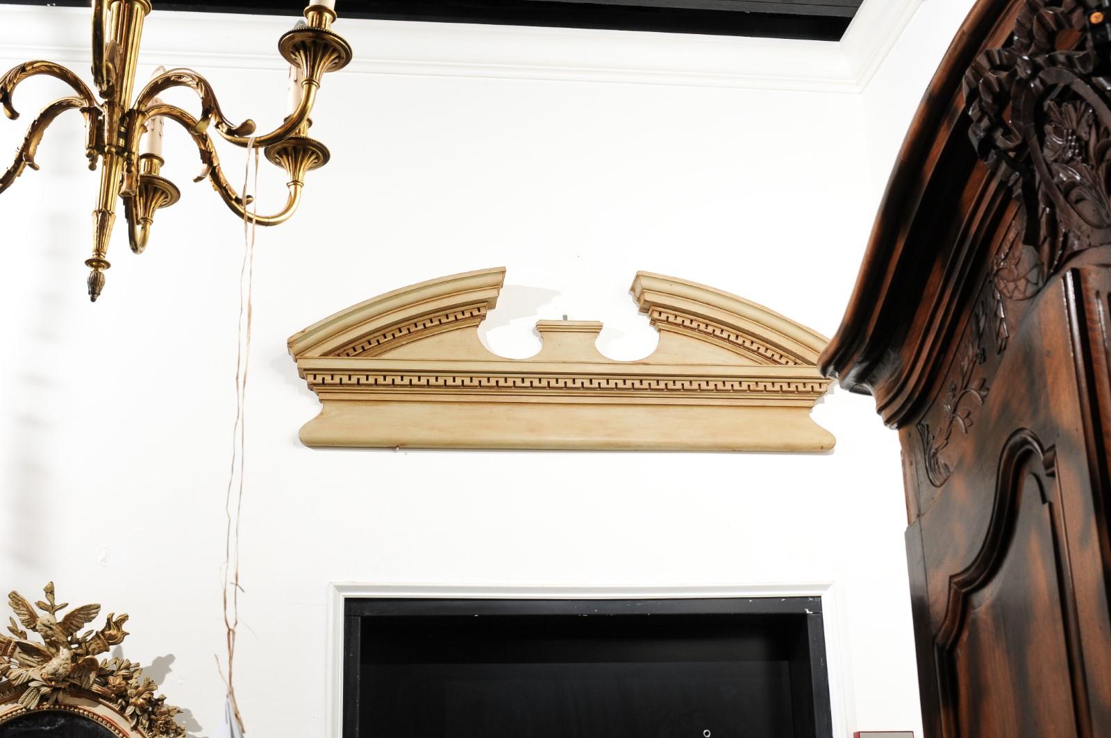 An English painted wood broken arch pediment from the late 19th century, with carved molding. Born in England during the later years of the 19th century, this exquisite architectural element features a broken arch silhouette, with curving, pierced