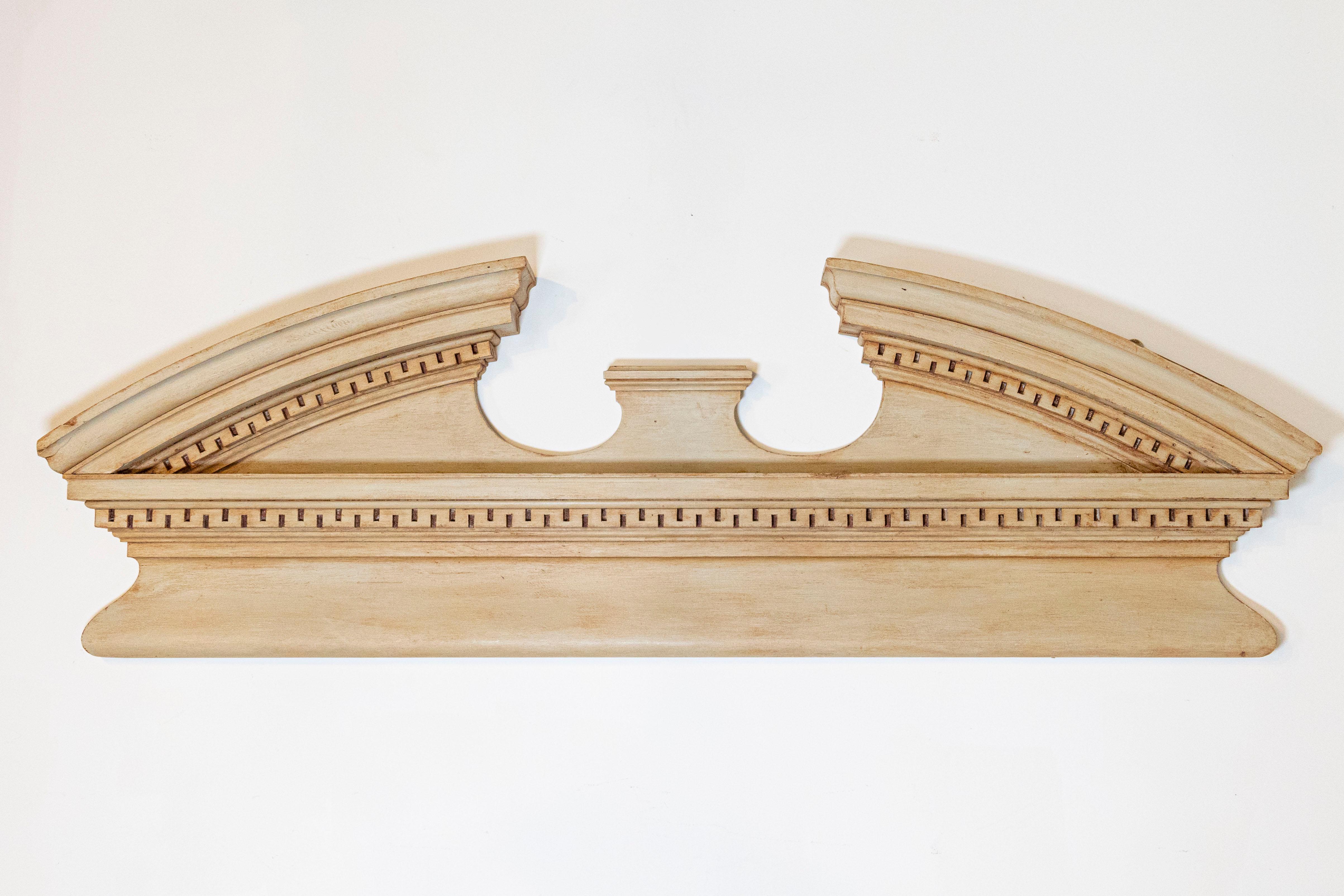An English painted wood broken arch pediment from the late 19th century, with carved molding. Born in England during the later years of the 19th century, this exquisite architectural element features a broken arch silhouette, with curving, pierced
