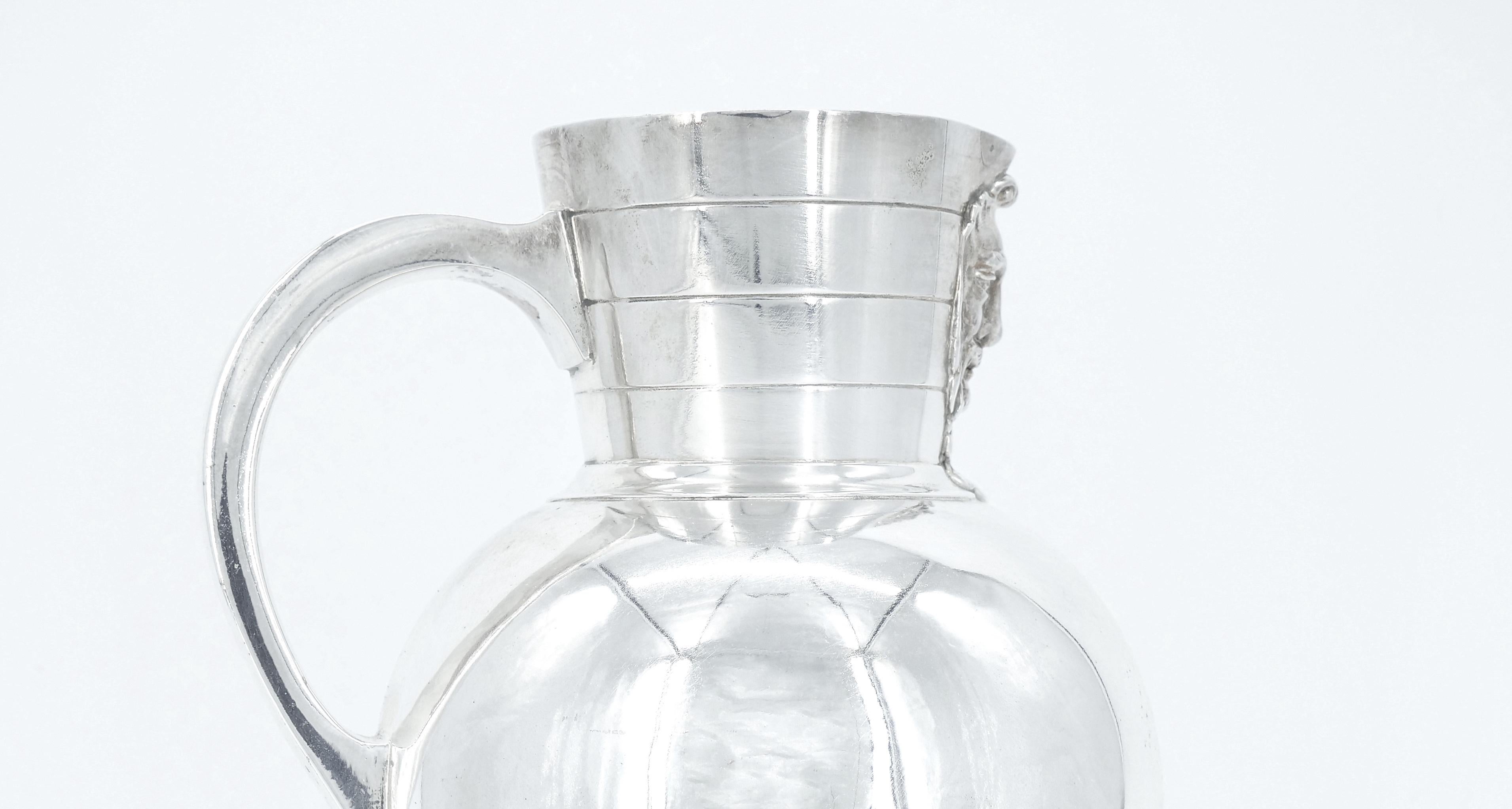 Step back in time with our exquisite late 19th century English silver plate water jug tableware serving pitcher. Crafted with meticulous attention to detail with its face sprout opening and one single attached holding handle, this pitcher