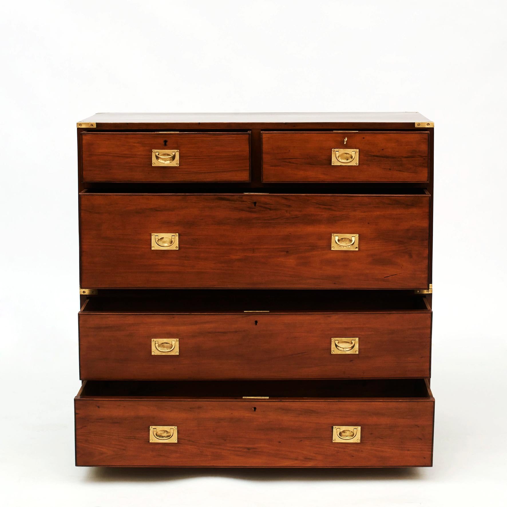 English Military Campaign chest of drawers in solid teak wood. In two parts. Original brass fittings.
England 1870-1880.
Great condition finished with a very gentle shellac hand polish (French polish).

Campaign -era chests were the travel items