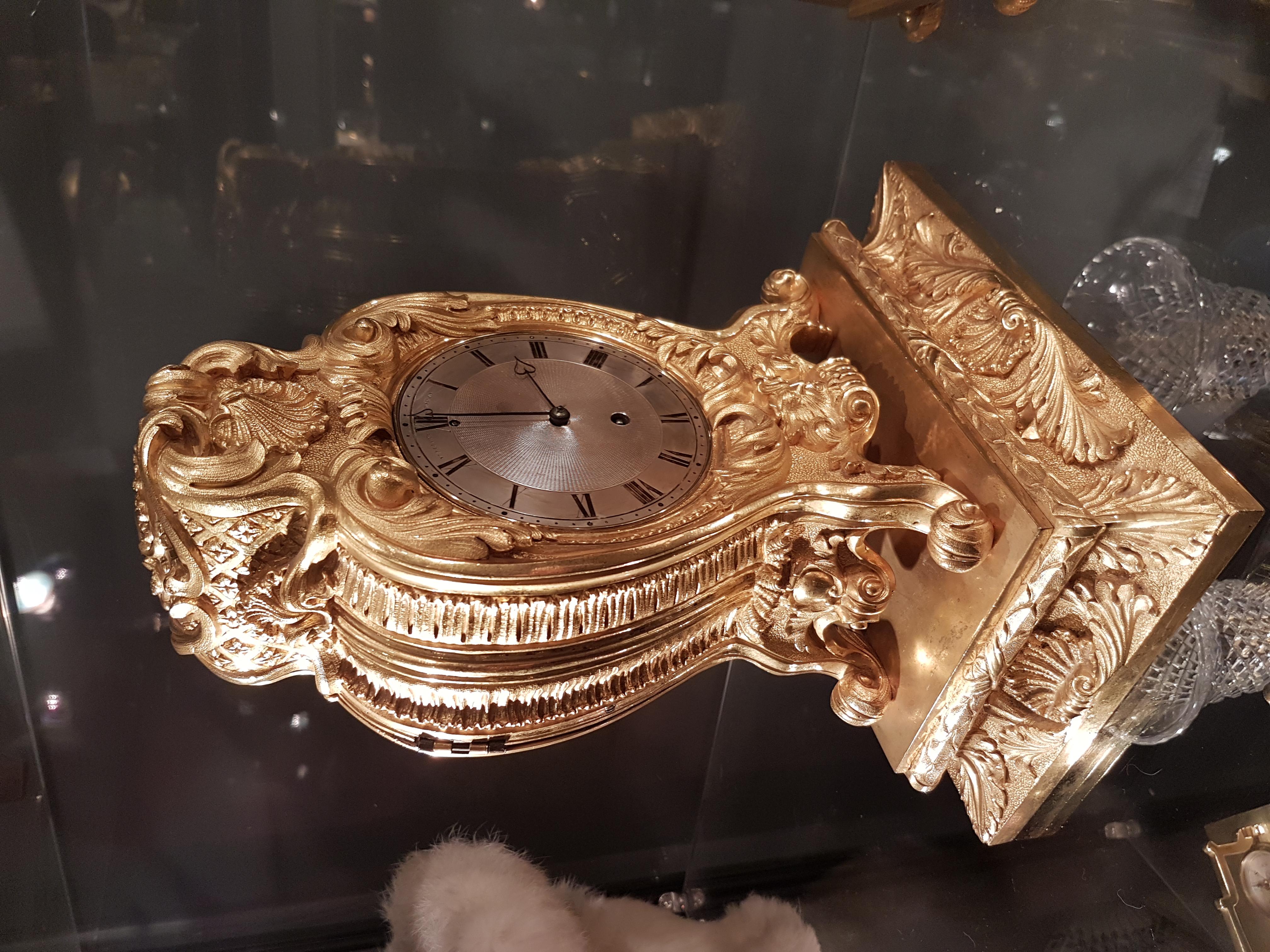 A good second quarter of the 19th century English ormolu mantel clock. Originally sold to Dr Burney on 23rd December 1826. Vulliamy, London, number 930 The heavy case cast with foliate scrolls, shells and centred by a mask at the base, the four